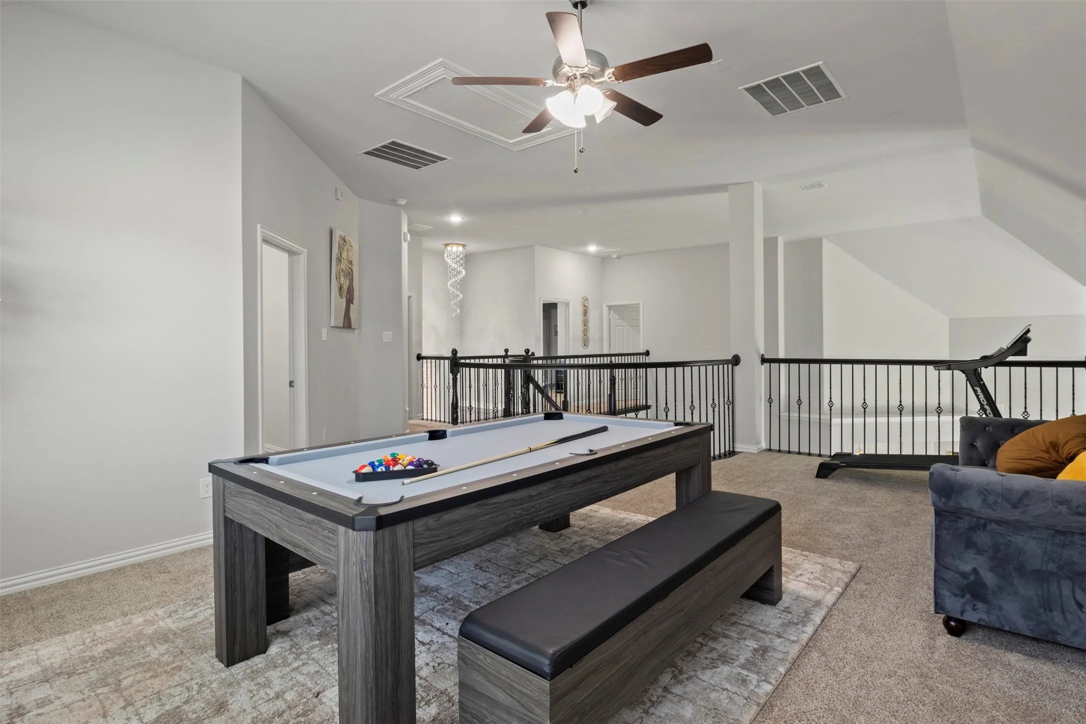 Open loft space featuring carpet flooring and an overhead ceiling fan