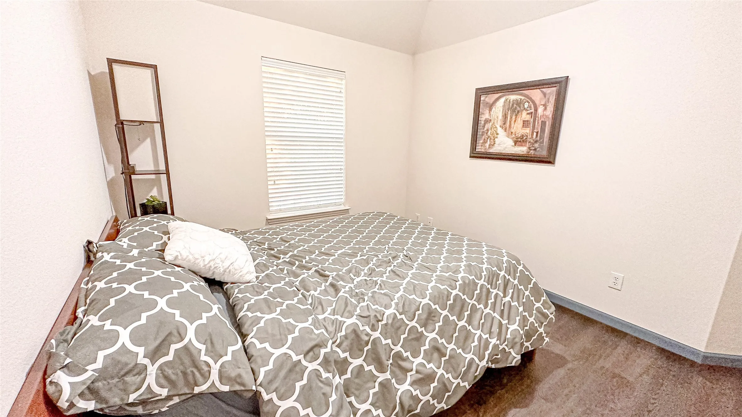 Carpeted bedroom with lofted ceiling