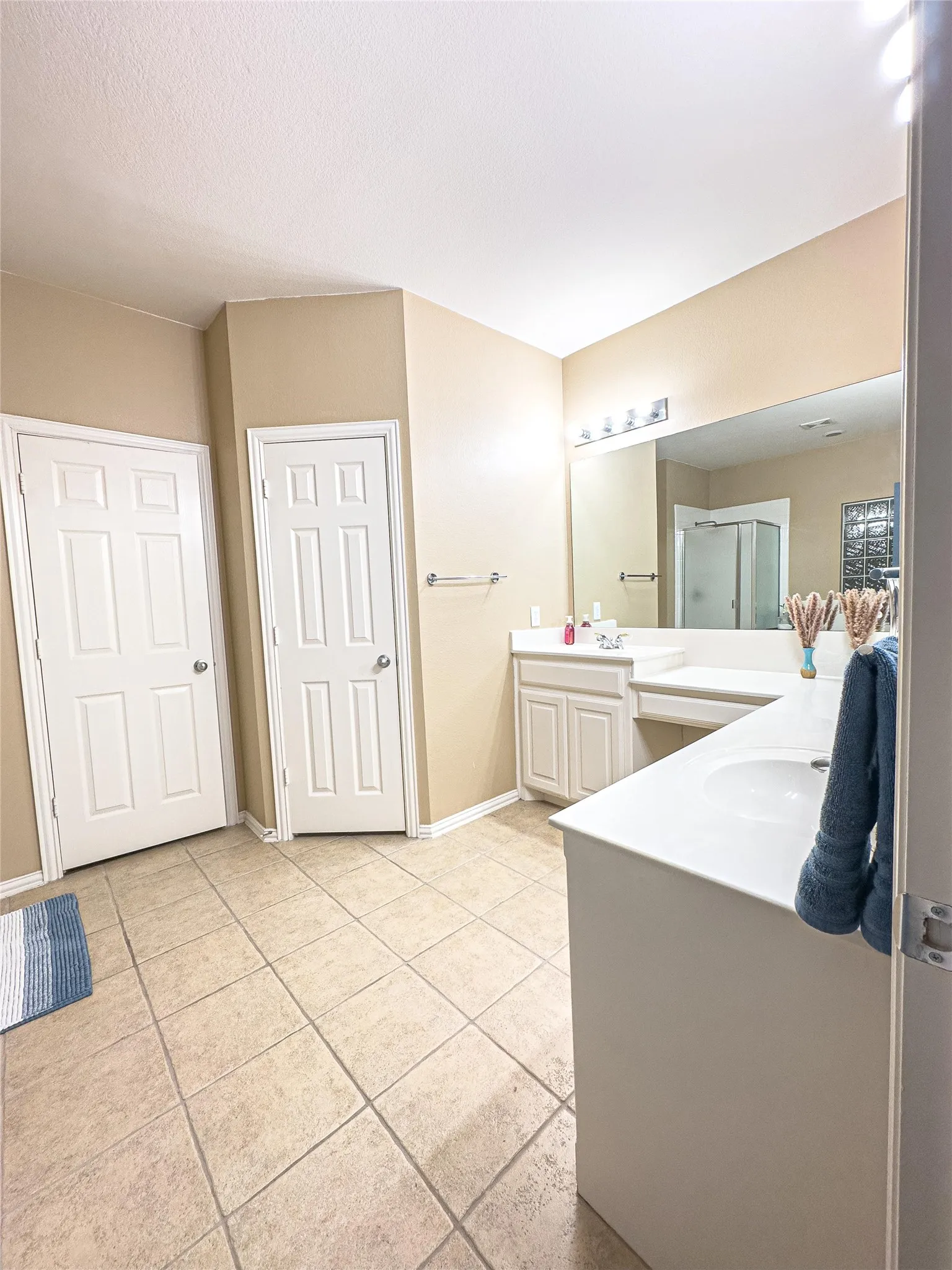 Full bath featuring tile patterned floors, a stall shower, vanity, and baseboards