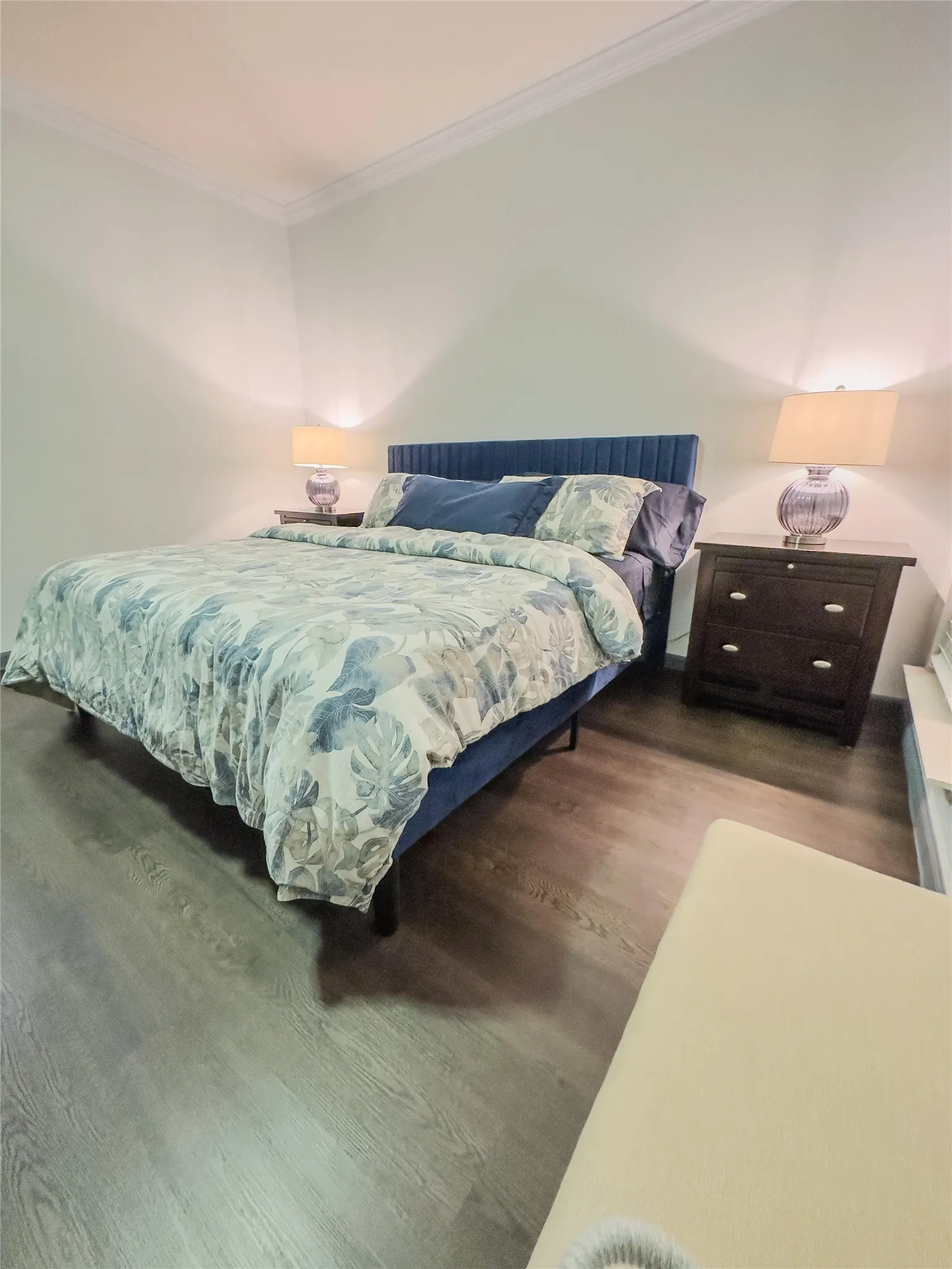 Bedroom featuring ornamental molding and wood finished floors