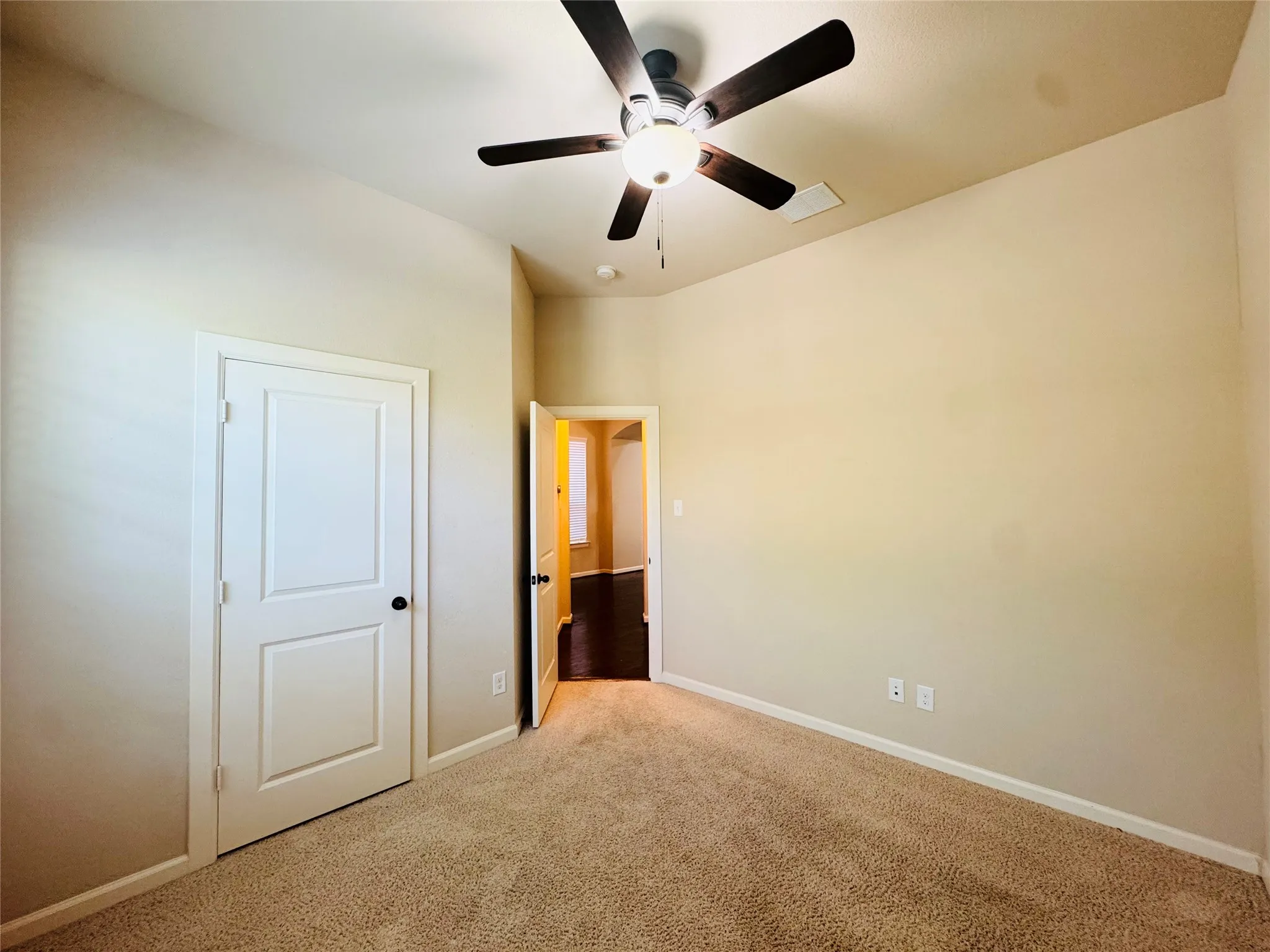 Carpeted flooring, neutral wall paint, white trim, ceiling fan with light fixture