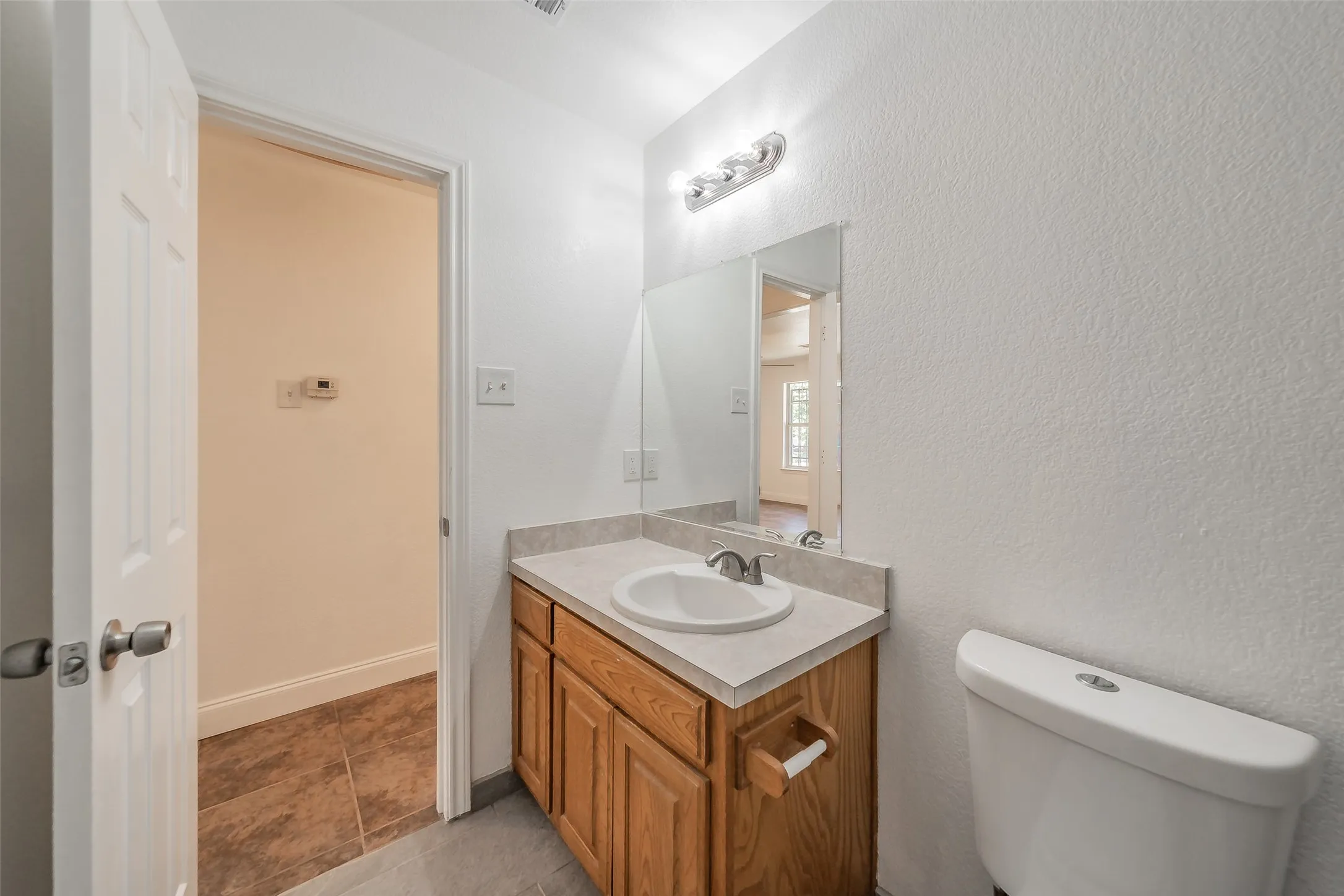 Wood-finish vanity with an integrated sink and light-toned countertop