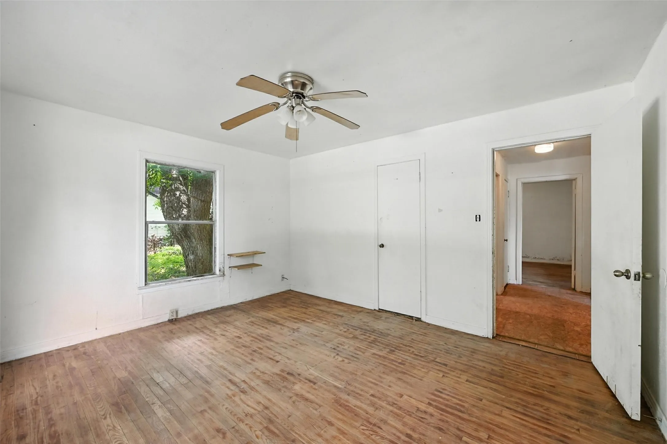 Unfurnished bedroom featuring wood-type flooring and a ceiling fan