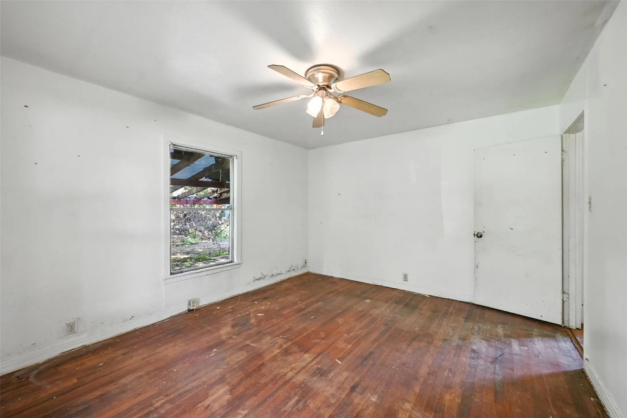 Spare room featuring dark wood-style flooring and a ceiling fan