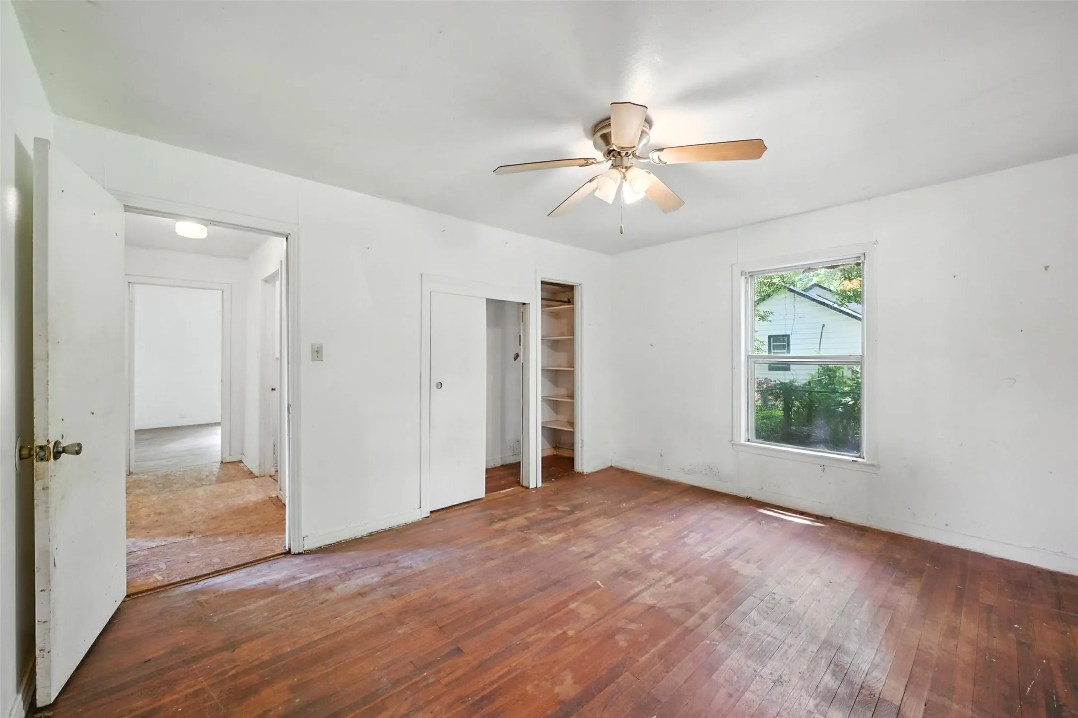 Unfurnished bedroom with a closet, wood-type flooring, and a ceiling fan