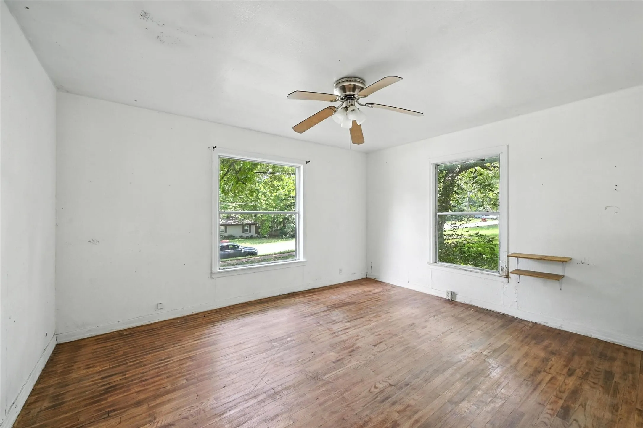 Empty room featuring dark wood finished floors and a ceiling fan