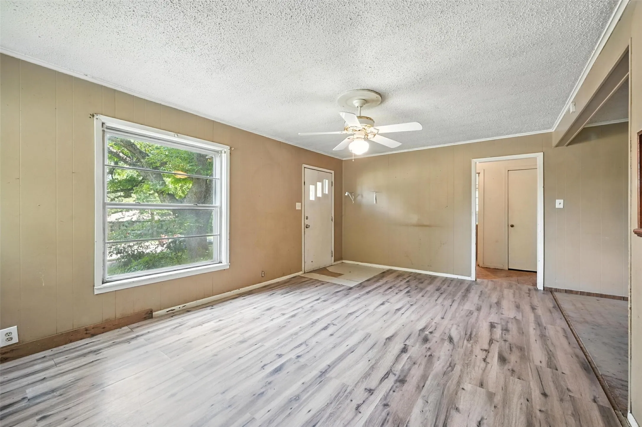 Foyer entrance featuring light wood-type flooring, ceiling fan, and a textured ceiling