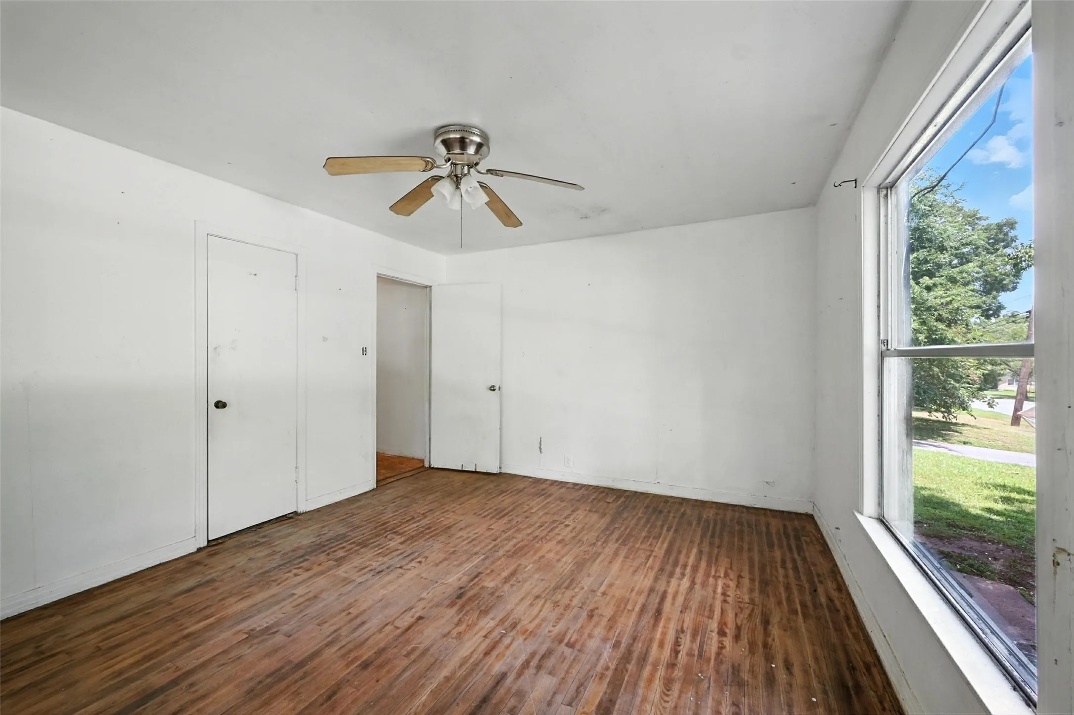 Unfurnished bedroom featuring dark wood-style floors and ceiling fan
