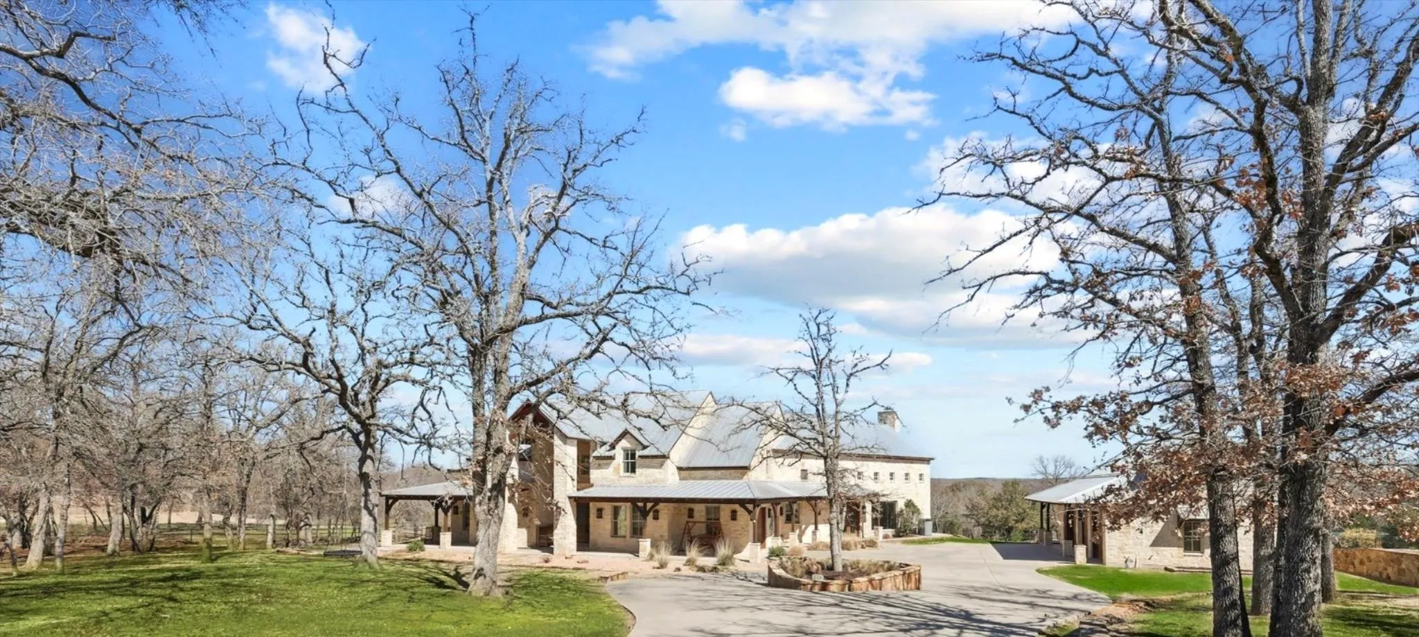 Front exterior view with curved driveway, front lawn, and covered porch.