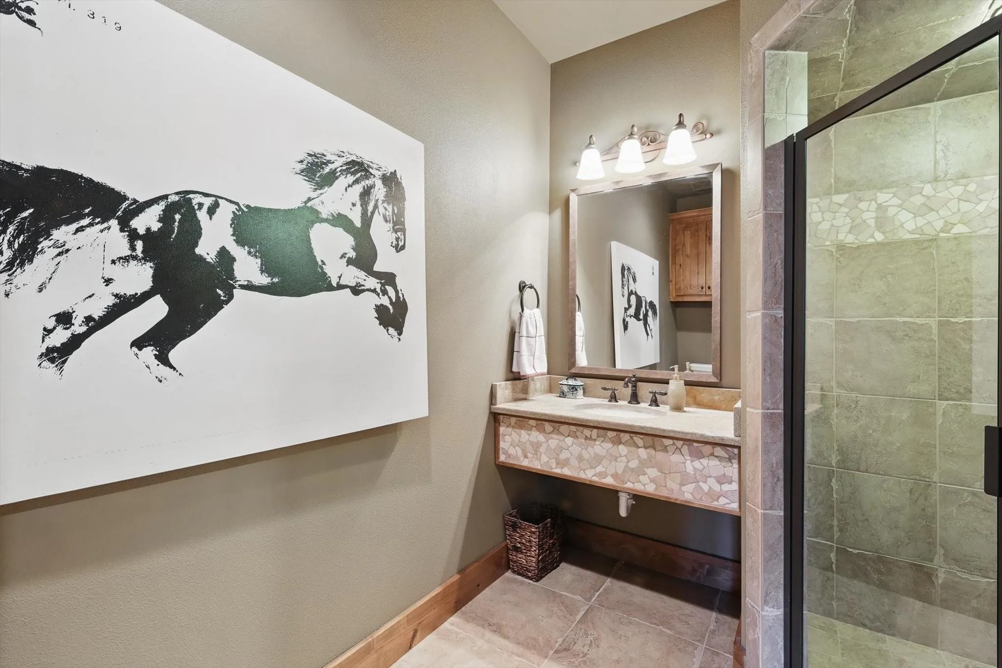 Bathroom featuring stall shower, patterned tile flooring, and vanity.