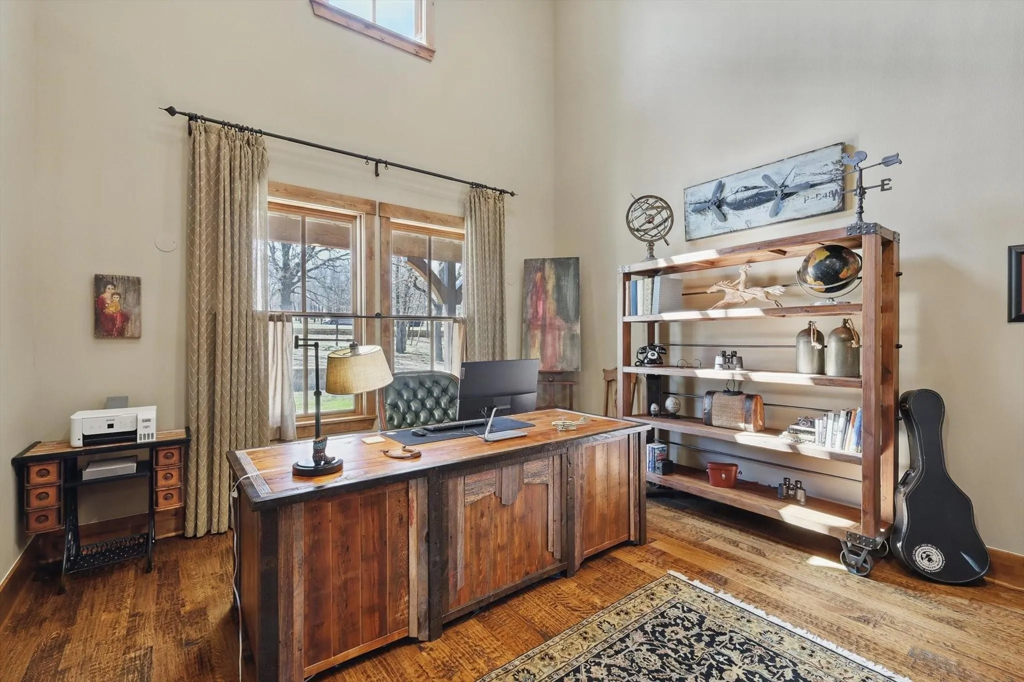 Office with dark wood-style flooring and high ceiling.
