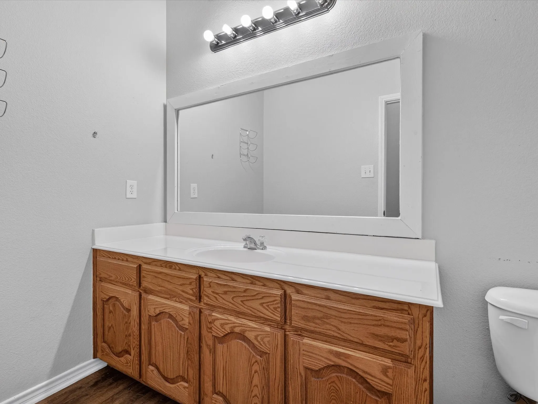 Wood-finish vanity with an integrated sink and light-colored countertop