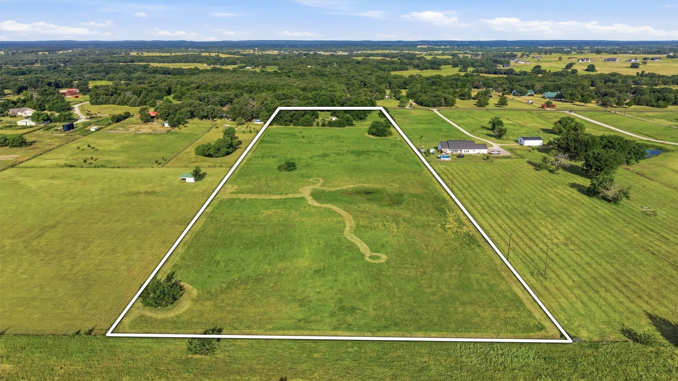 Open pasture in the back with a pond