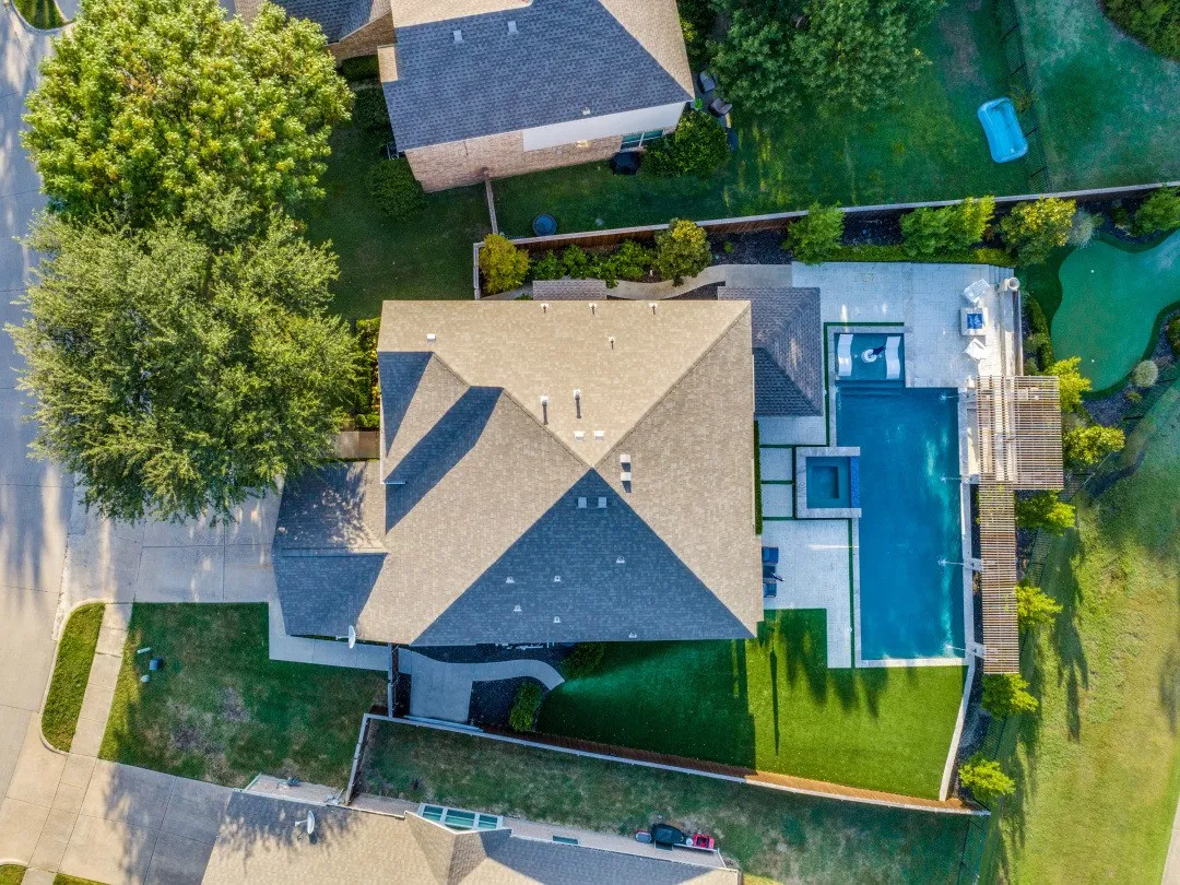 Backyard with a swimming pool, integrated spa, putting green, artificial turf, and extensive hardscaping