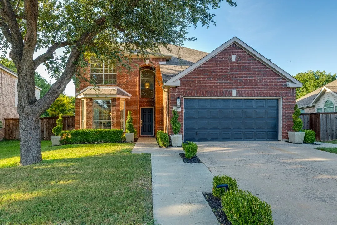 Brick exterior, front entry with arched window, bay window, landscaped front yard, and concrete driveway