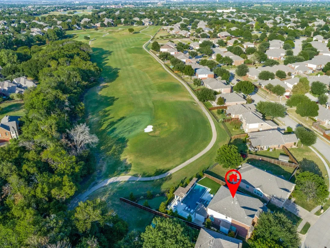 Rear property featuring a private pool and artificial turf, bordering a golf course with mature trees and a residential neighborhood