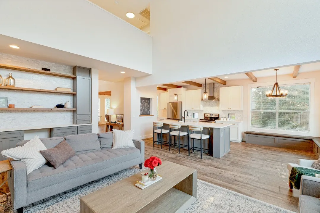 Vaulted ceiling, wood-finish flooring, exposed ceiling beams, built-in shelving, and a kitchen island with seating