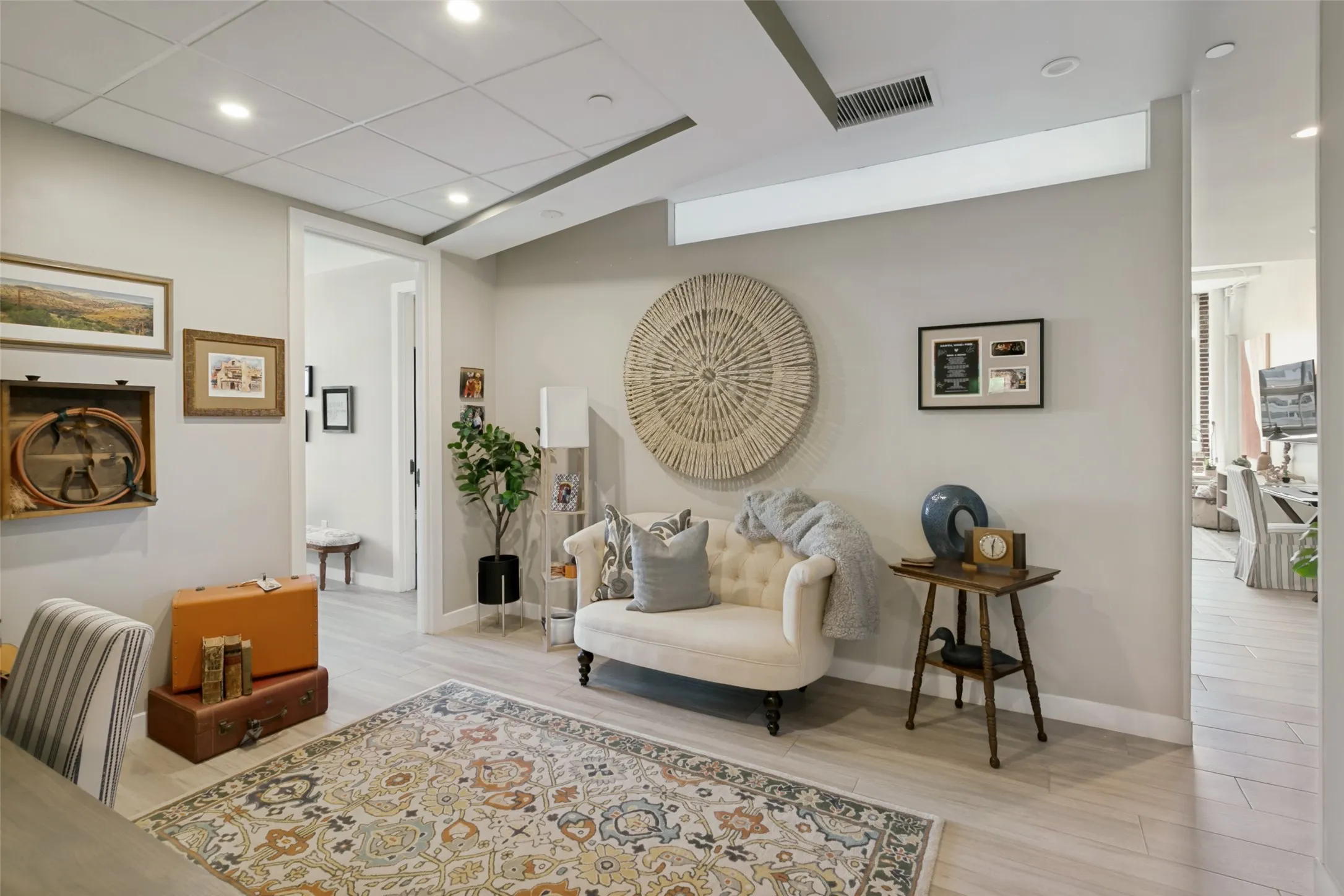 Recessed lighting, light-toned walls, porcelain wood-look flooring, and white trim throughout. Opposite view from built-in desk