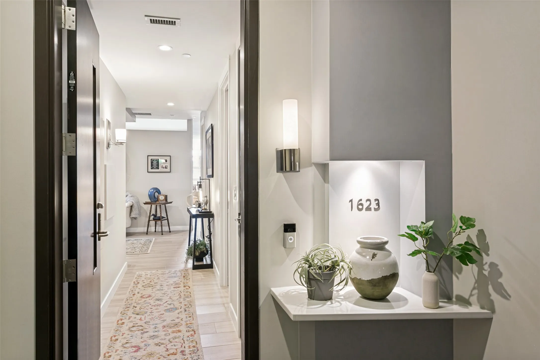Entryway featuring a wall-mounted sconce, light wood-finish flooring, and recessed lighting