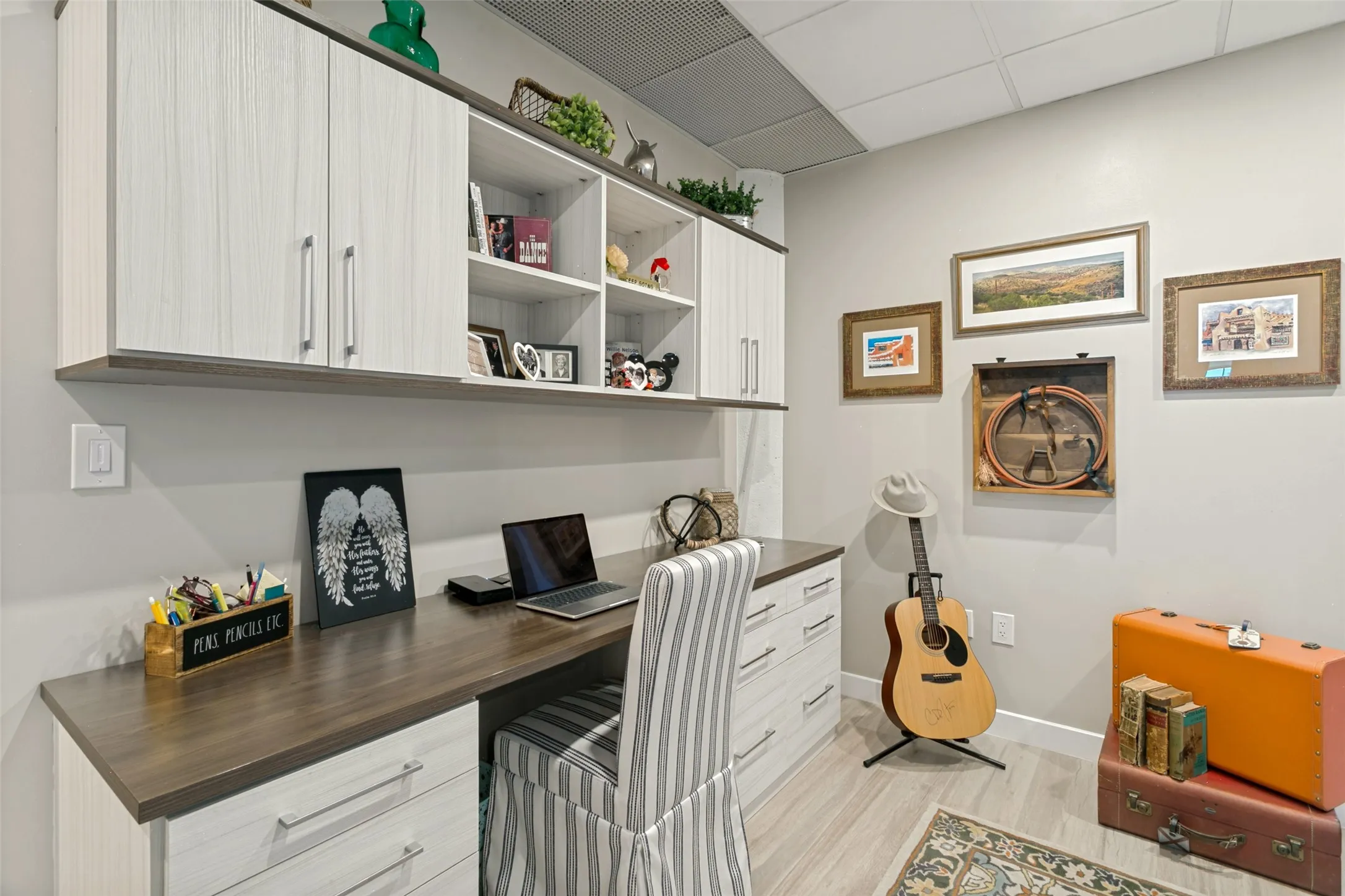 Built-in desk with wood-finish countertop, coordinating overhead cabinetry, integrated shelving, and porcelain wood-look flooring