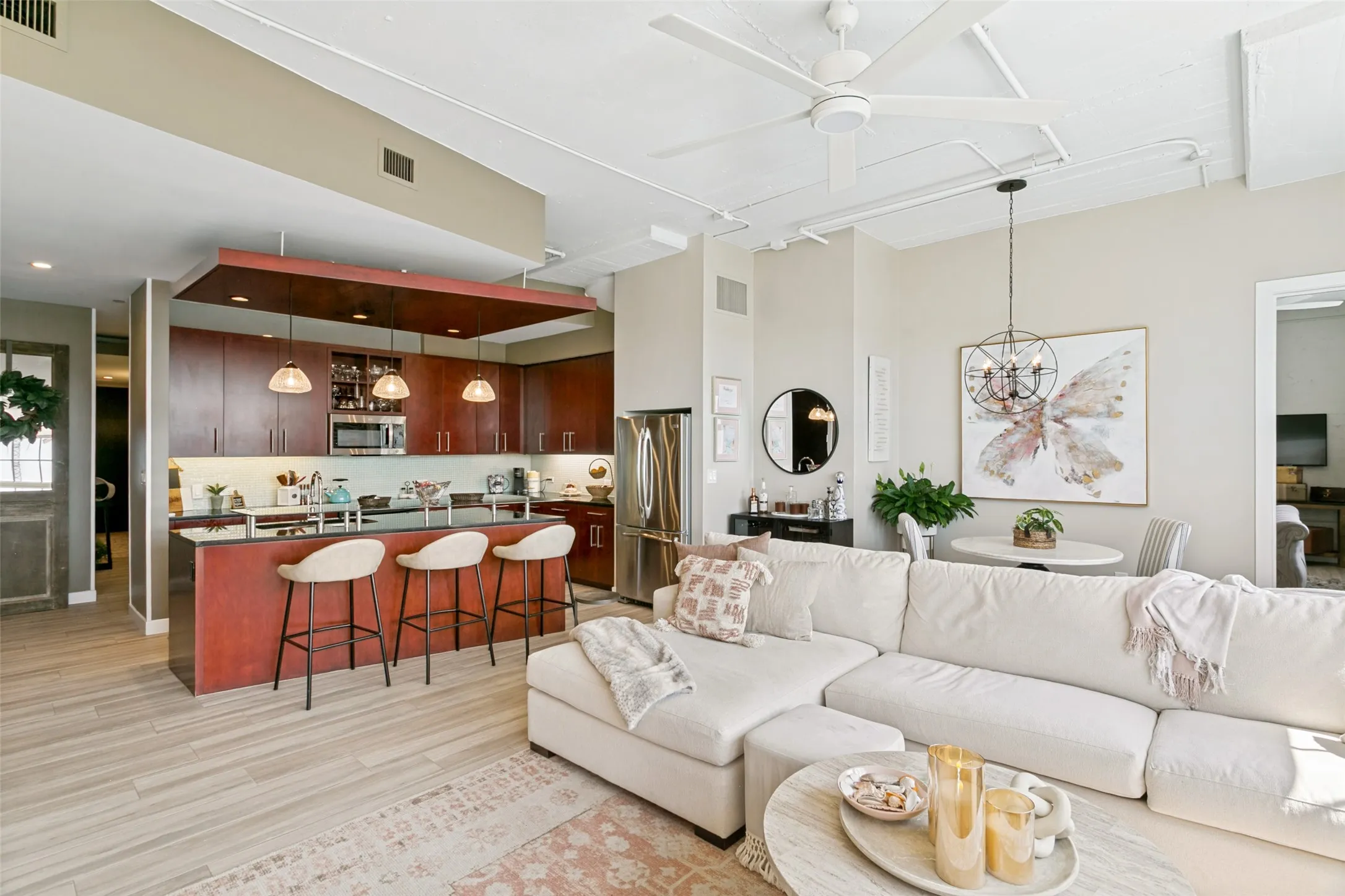 Open-concept living space featuring porcelain wood-look flooring and high ceilings with Minka fan