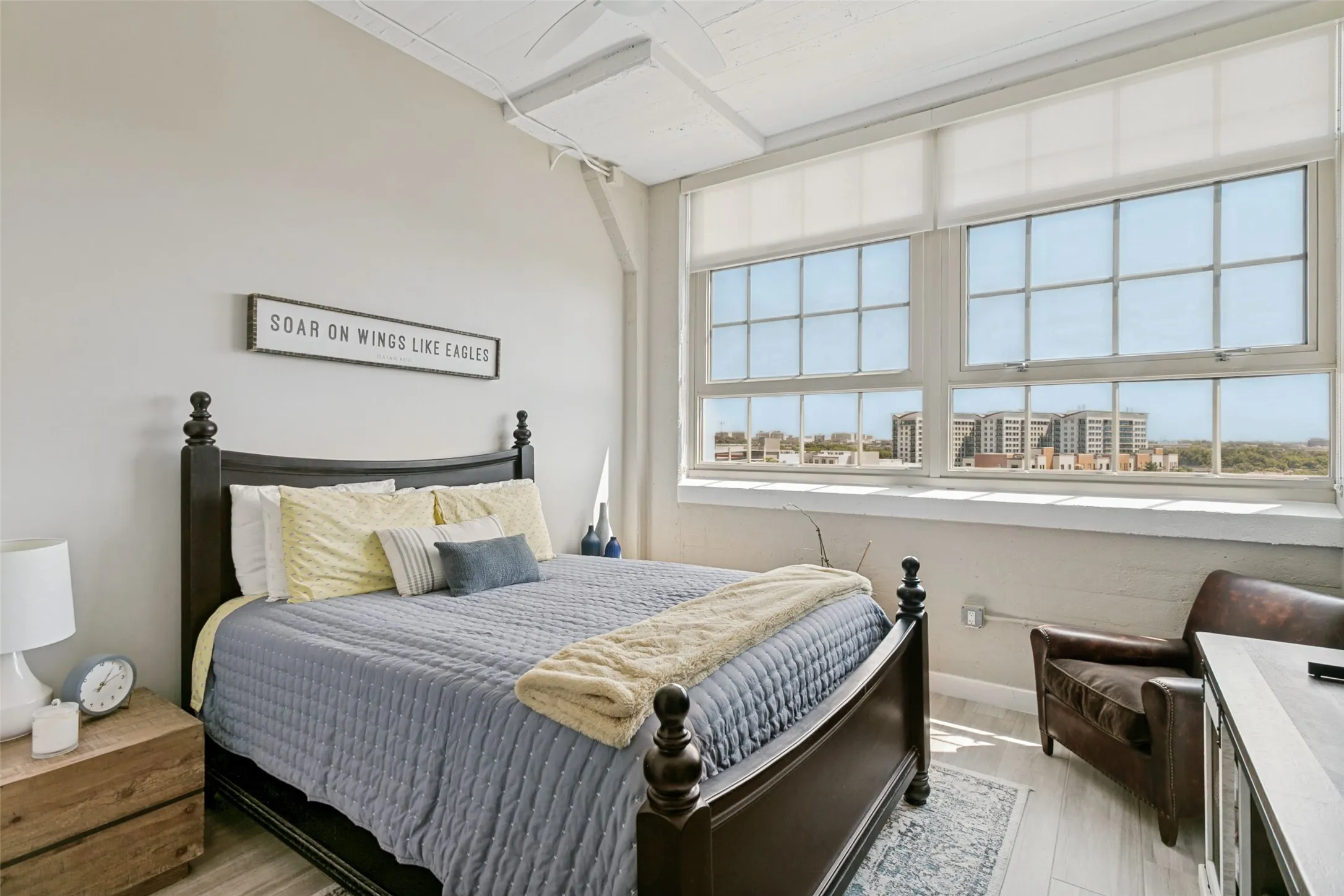 Expansive windows, porcelain wood-look flooring, exposed ceiling beams, and a ceiling fan
