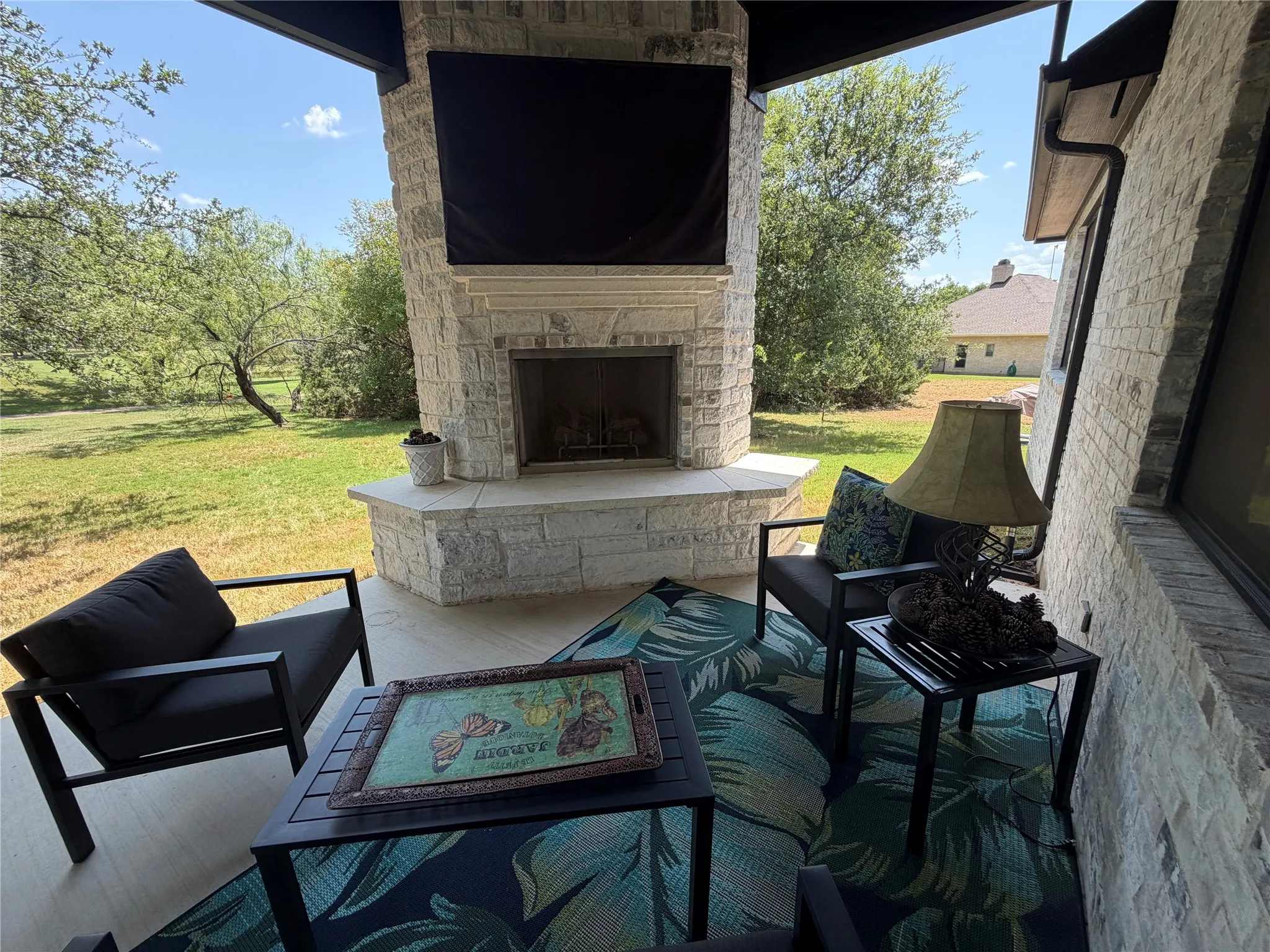 Back patio with gas fireplace and TV, situated on hole #9 of the New Course