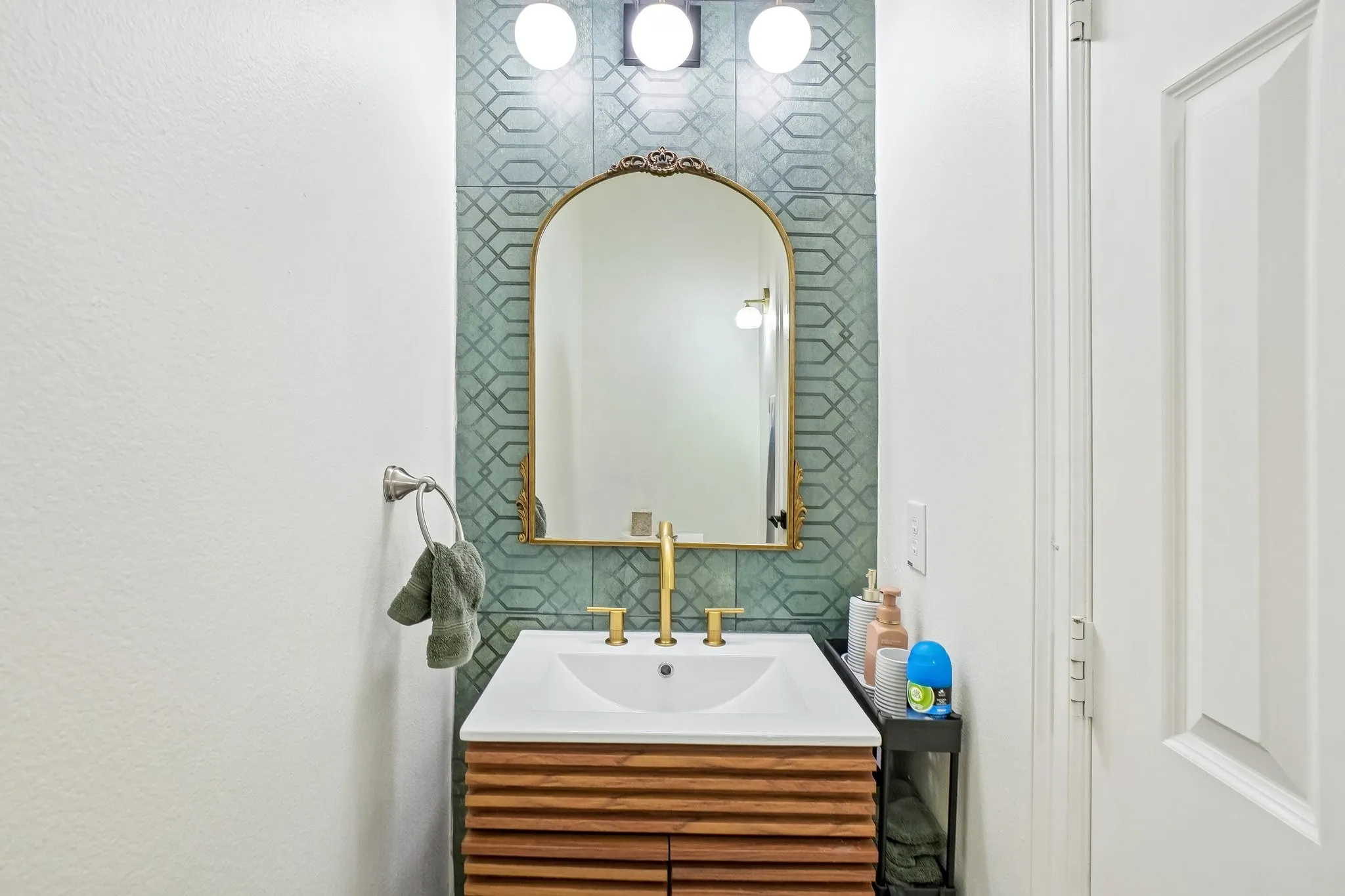 White vanity sink with gold-finish faucet