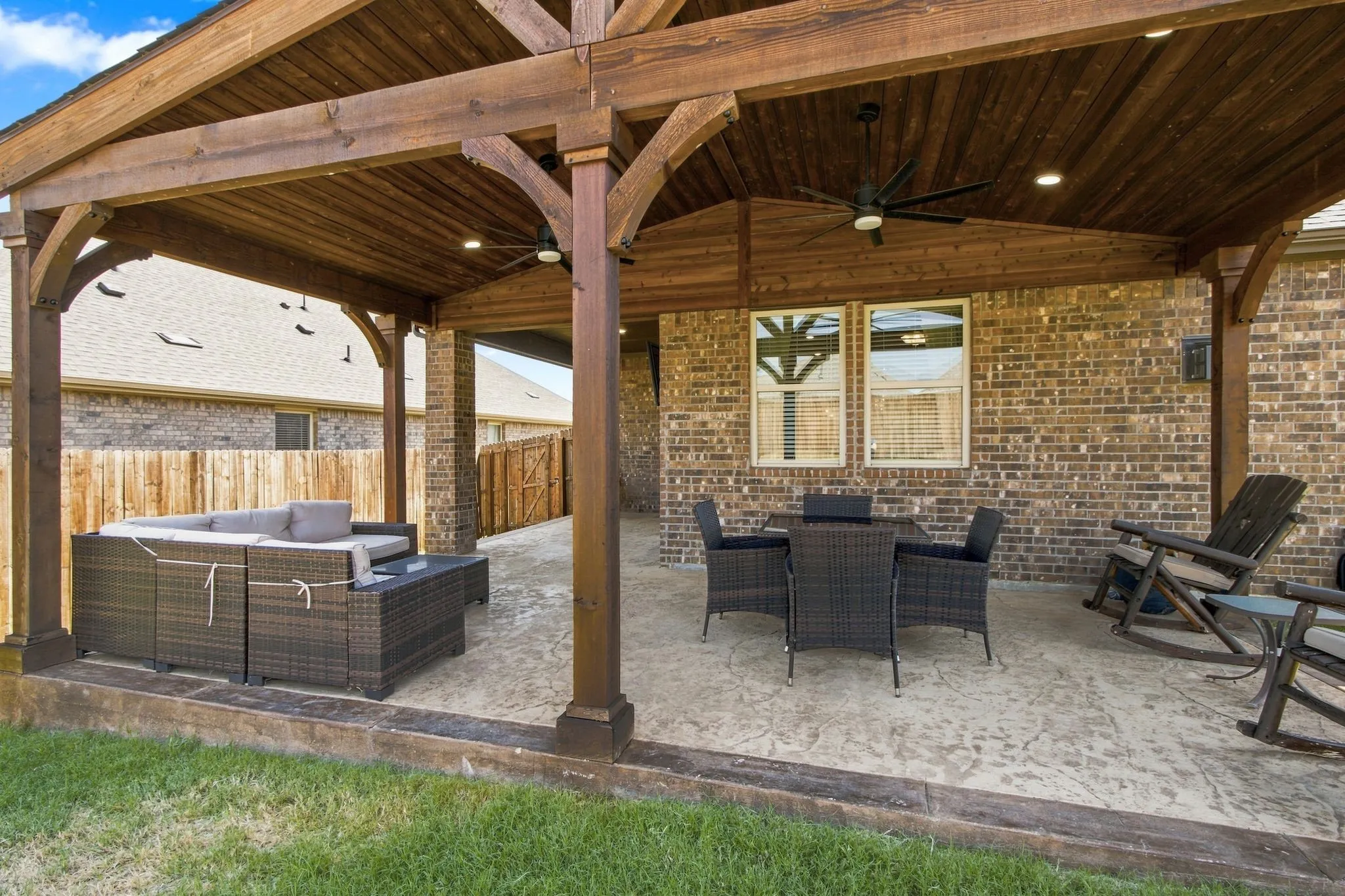 Custom built cedar patio with ceiling fans, add lighting,tv mount, colored stamped concrete