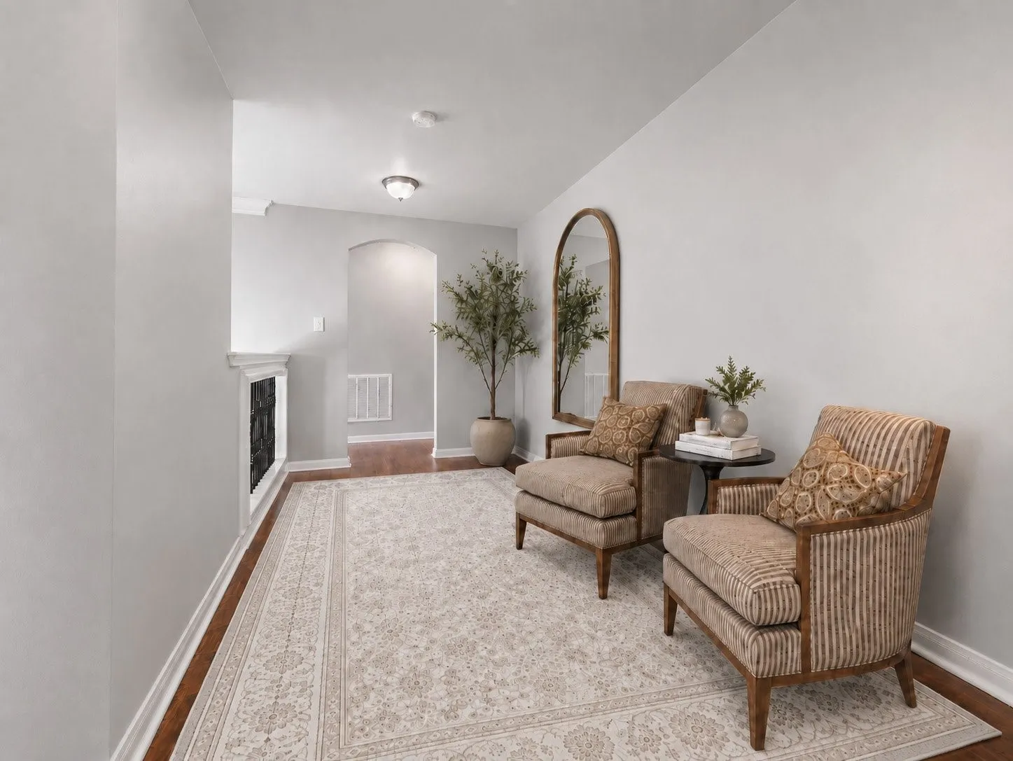 Hardwood-style flooring with white trim, an arched doorway, and recessed ceiling lighting