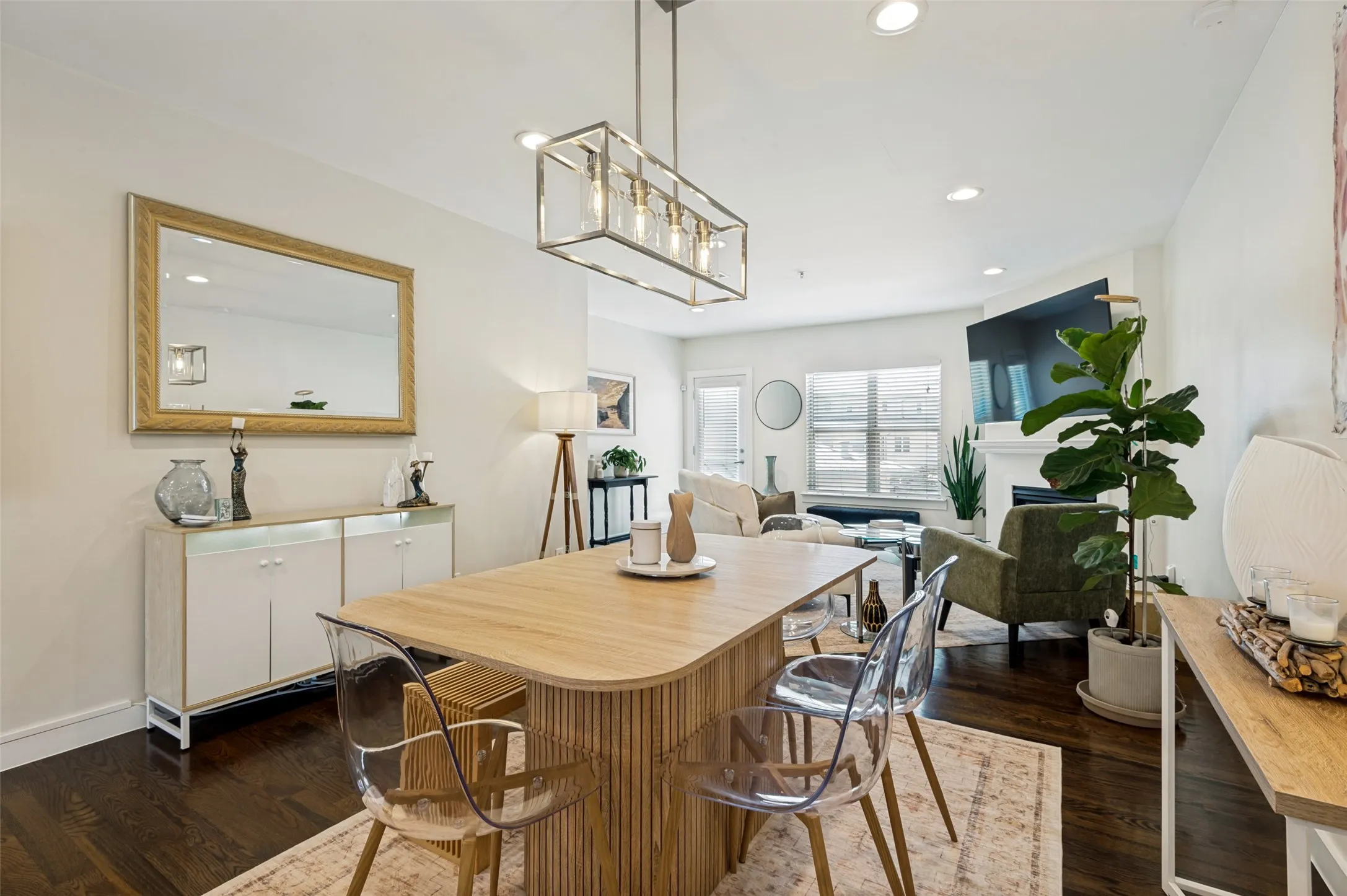 Open-concept living space with dark wood-finish flooring, recessed lighting, and a modern rectangular chandelier
