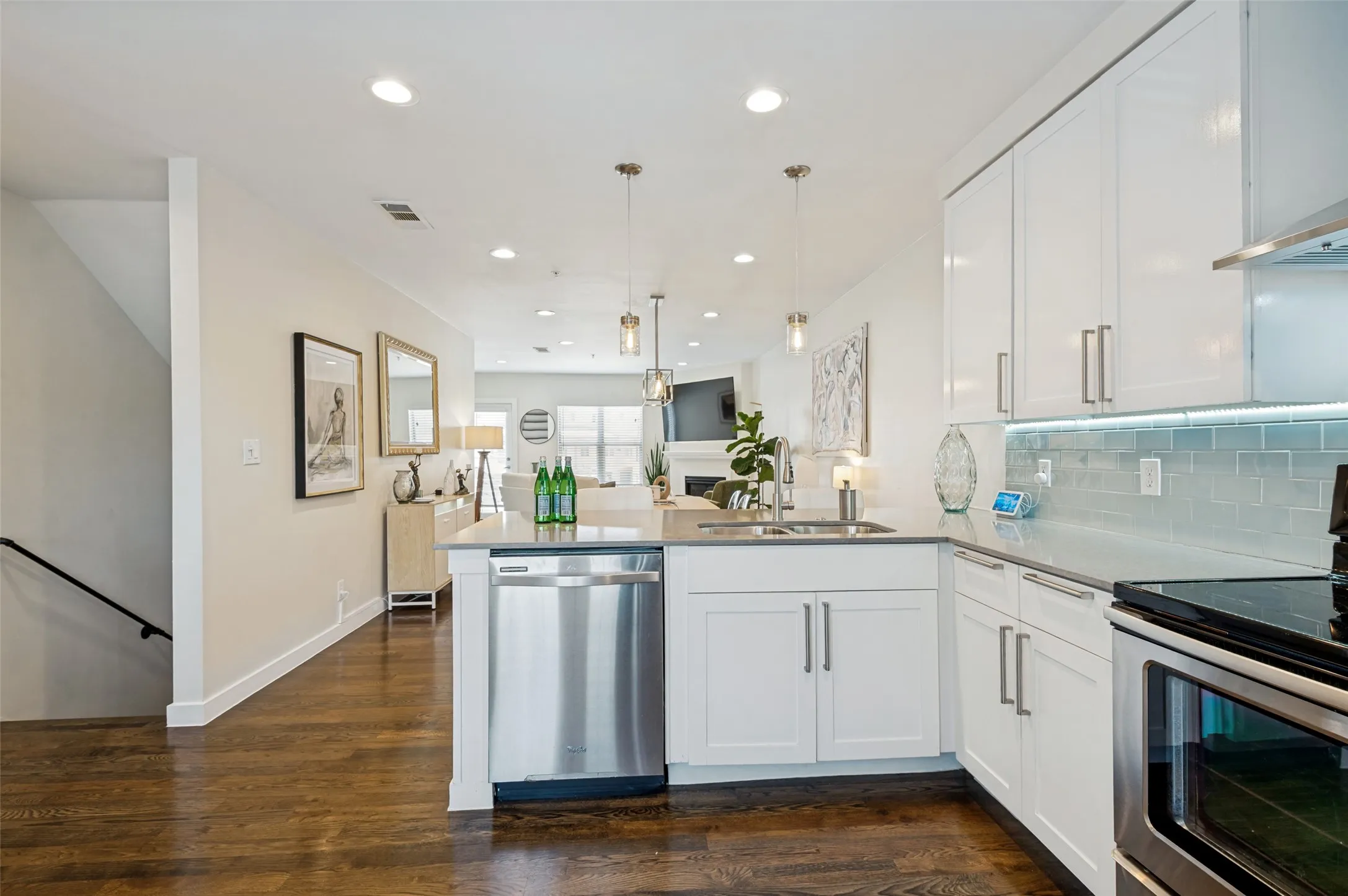 Kitchen featuring white cabinetry, stainless steel appliances, light-toned countertops, and a tiled backsplash