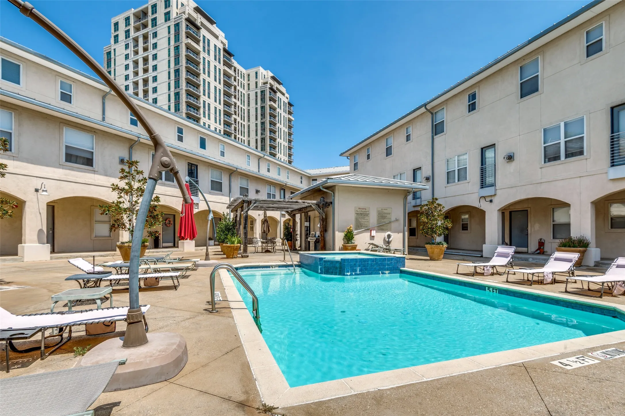 Outdoor swimming pool with integrated spa and surrounding concrete patio