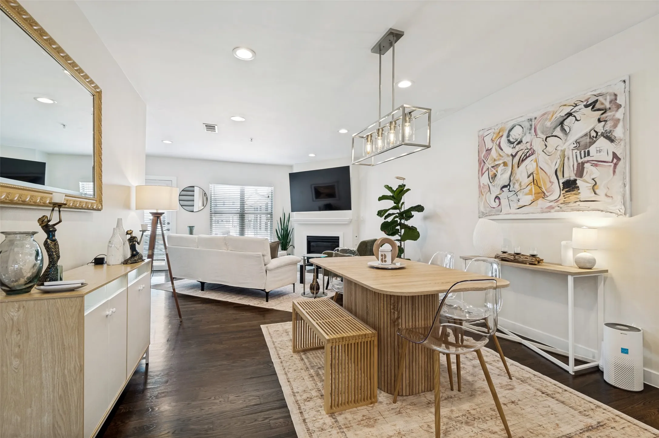 Dark wood-finish flooring throughout, recessed ceiling lighting, and a linear pendant light fixture