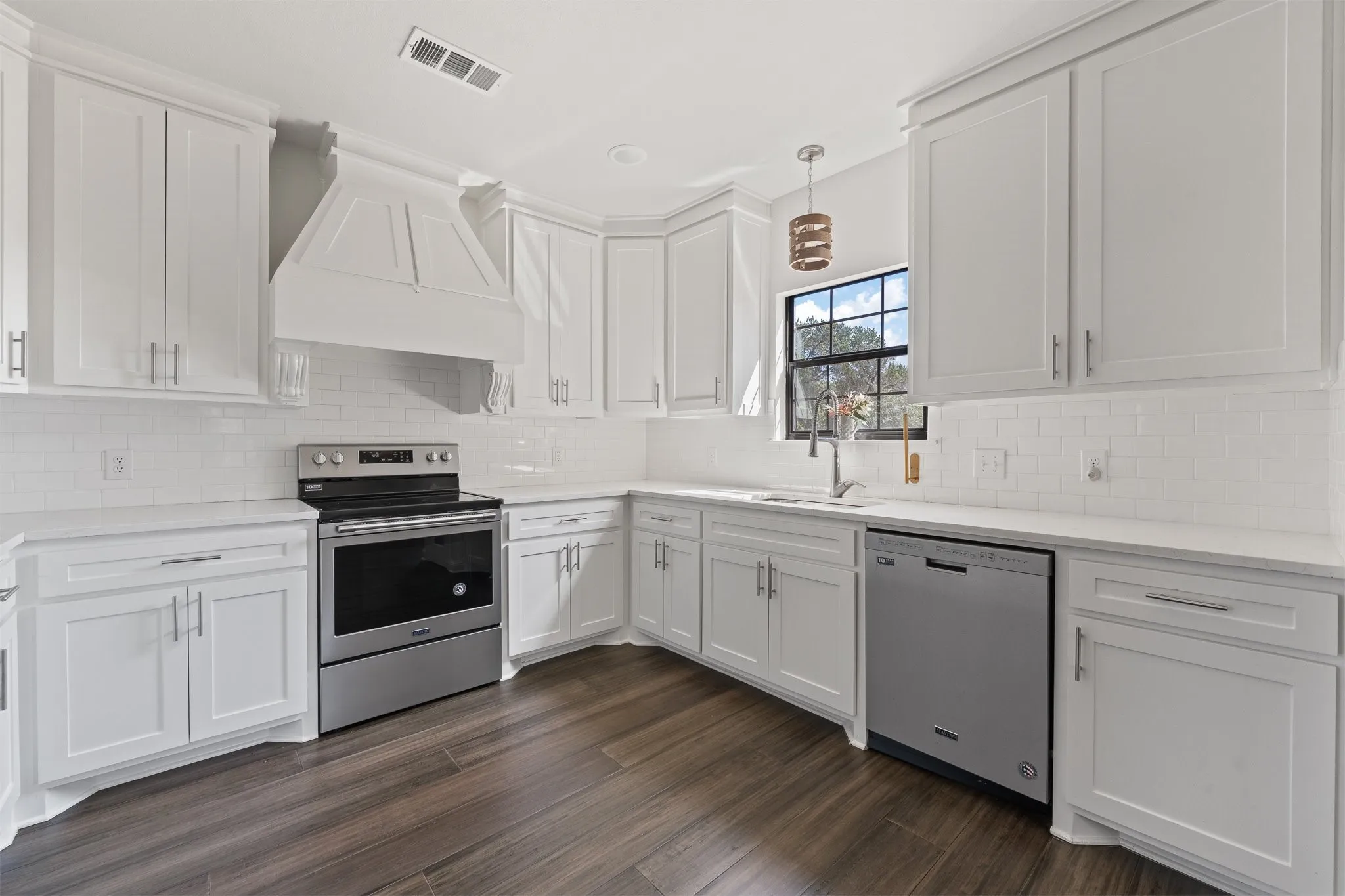 Gorgeous light and airy kitchen with stainless steel appliances.