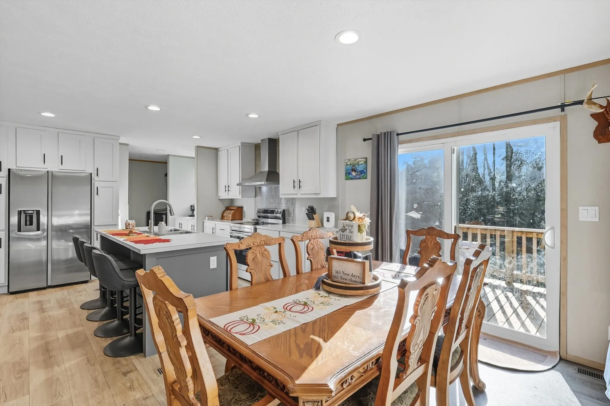 Dining room with light wood finished floors and recessed lighting