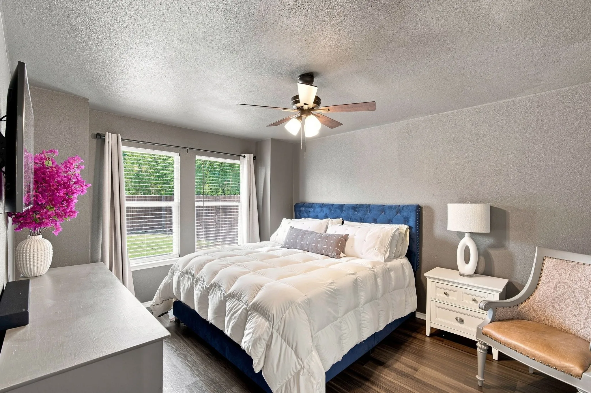 A calm, comfortable primary suite with soft natural light and a clean, modern feel