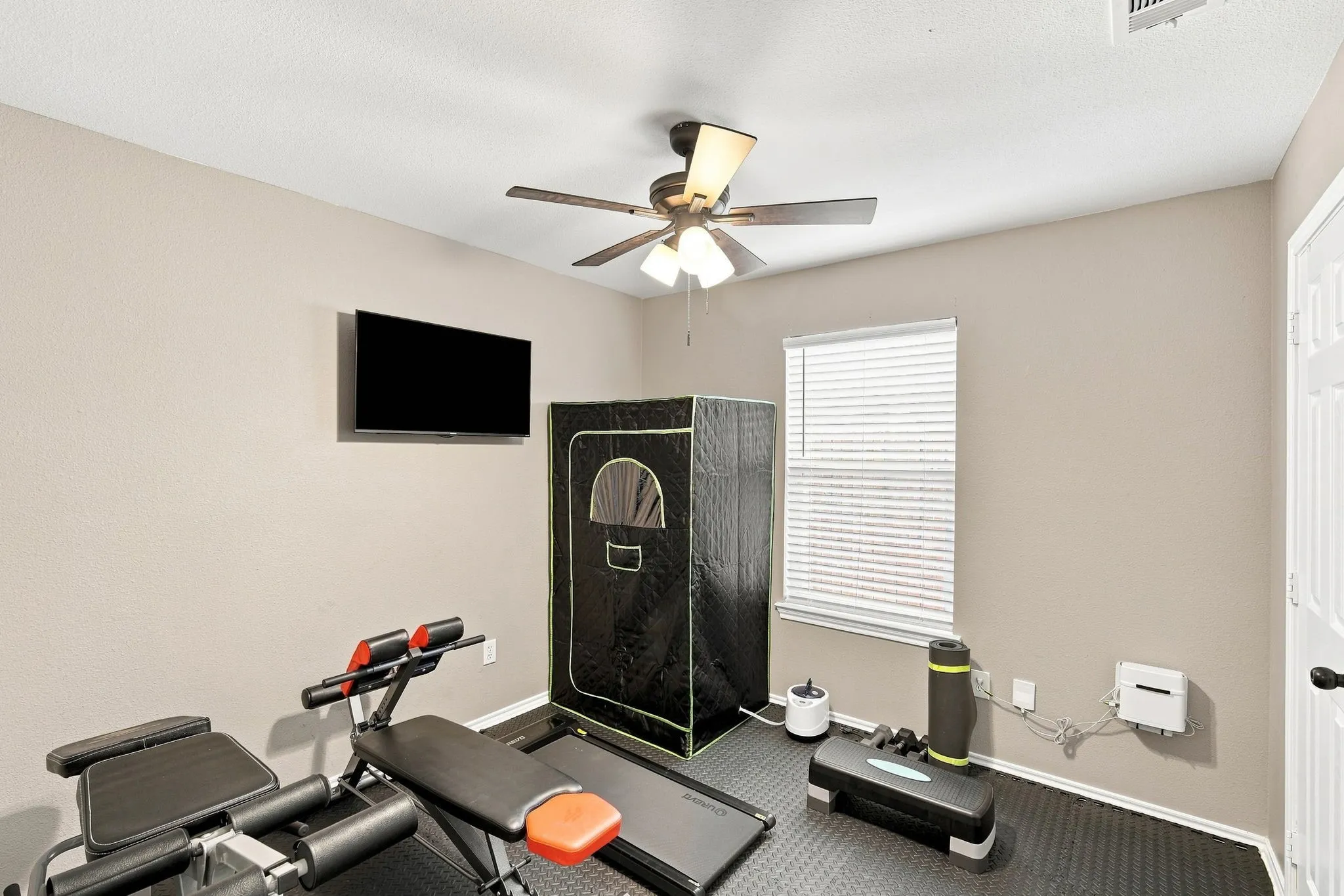 A full bedroom currently set up as a home gym — a flexible space that easily adapts to whatever you need