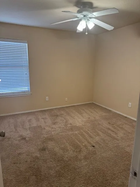 Neutral-toned walls complement the wall-to-wall carpeting