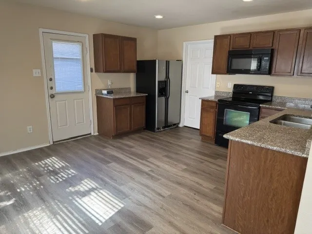 Wood-finish flooring, recessed lighting, and a stainless steel double basin sink