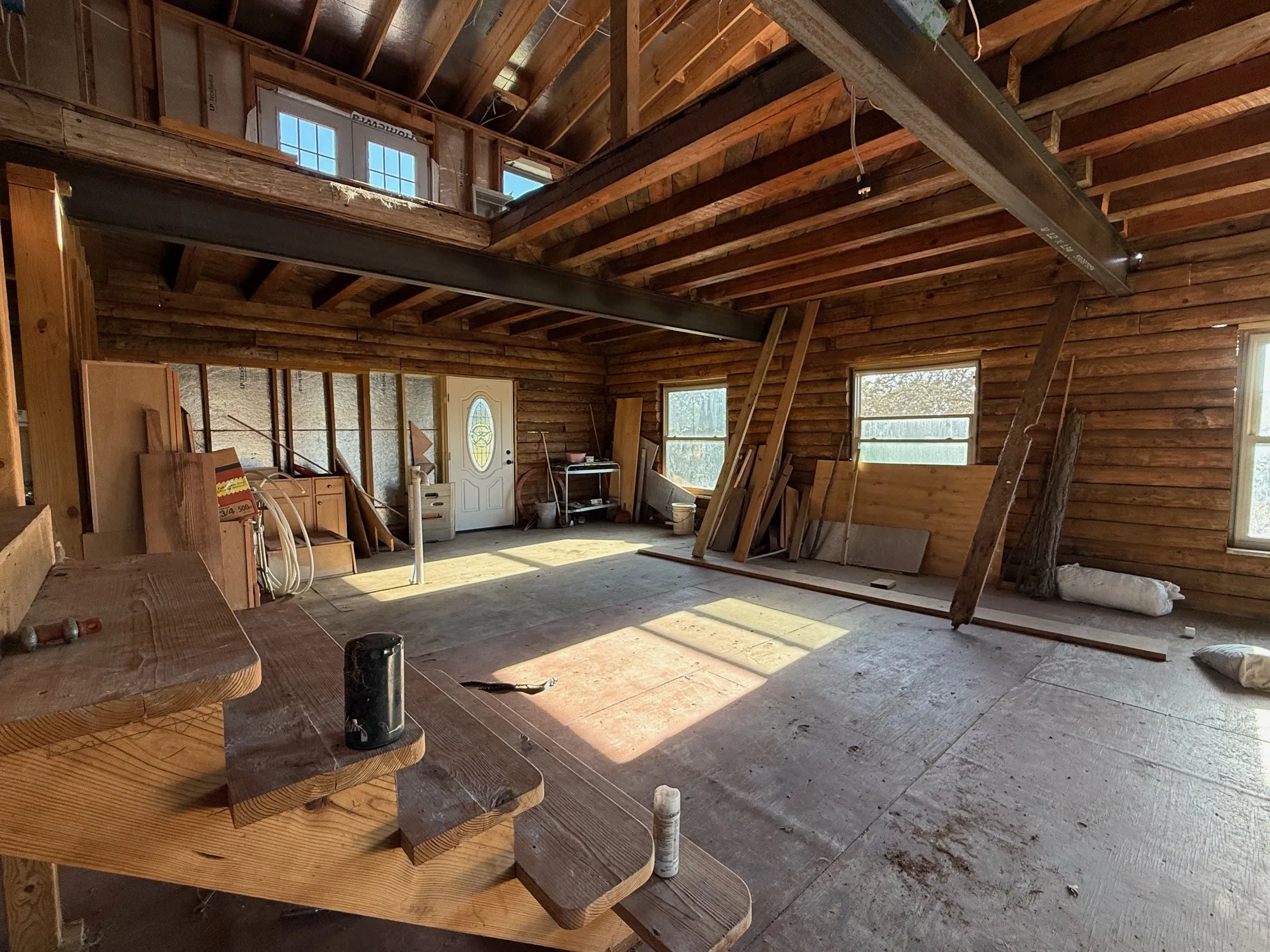 Rustic interior featuring exposed log walls and a prominent steel beam
