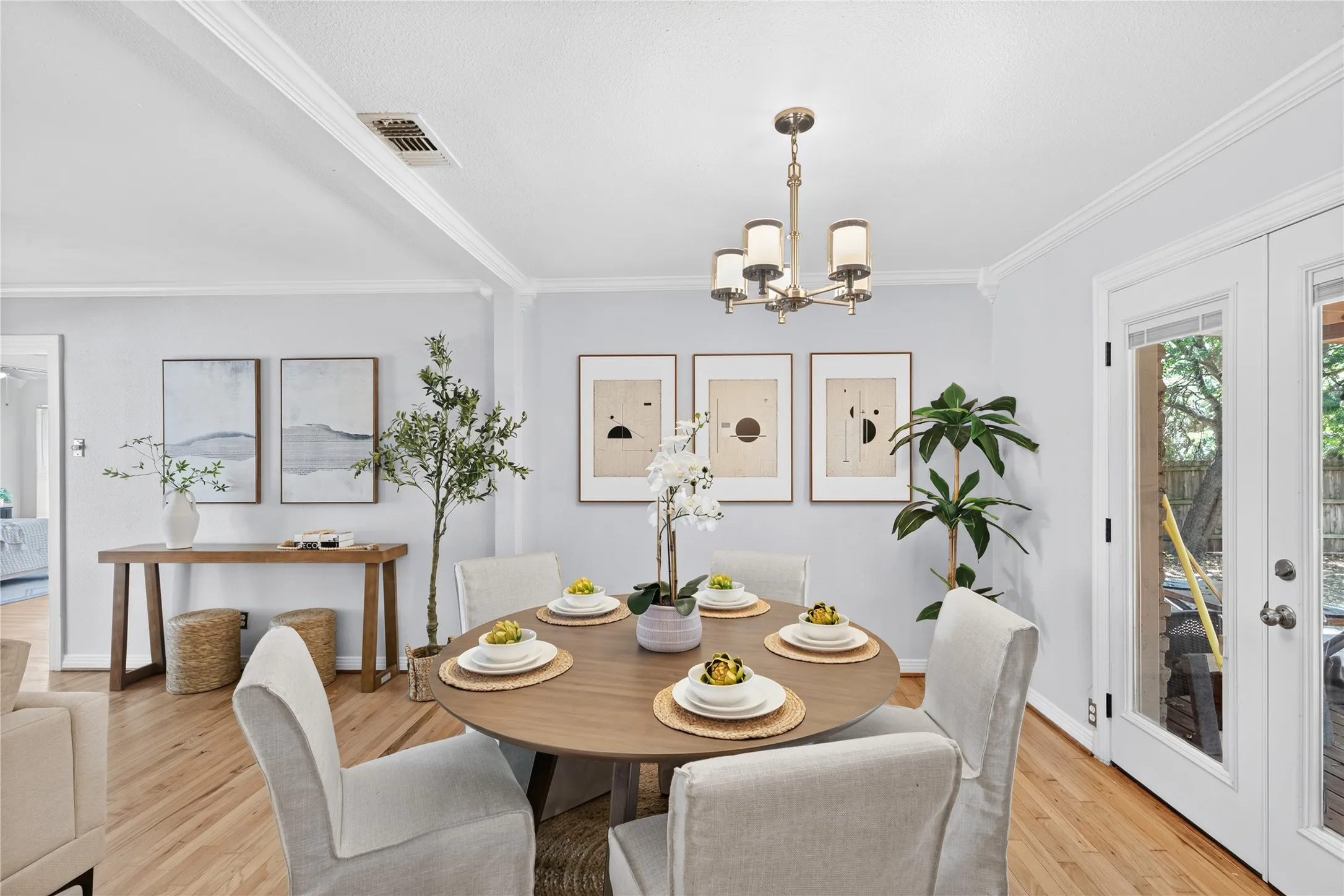 Hardwood flooring, crown molding, built-in ceiling light fixture, and French doors with privacy blinds