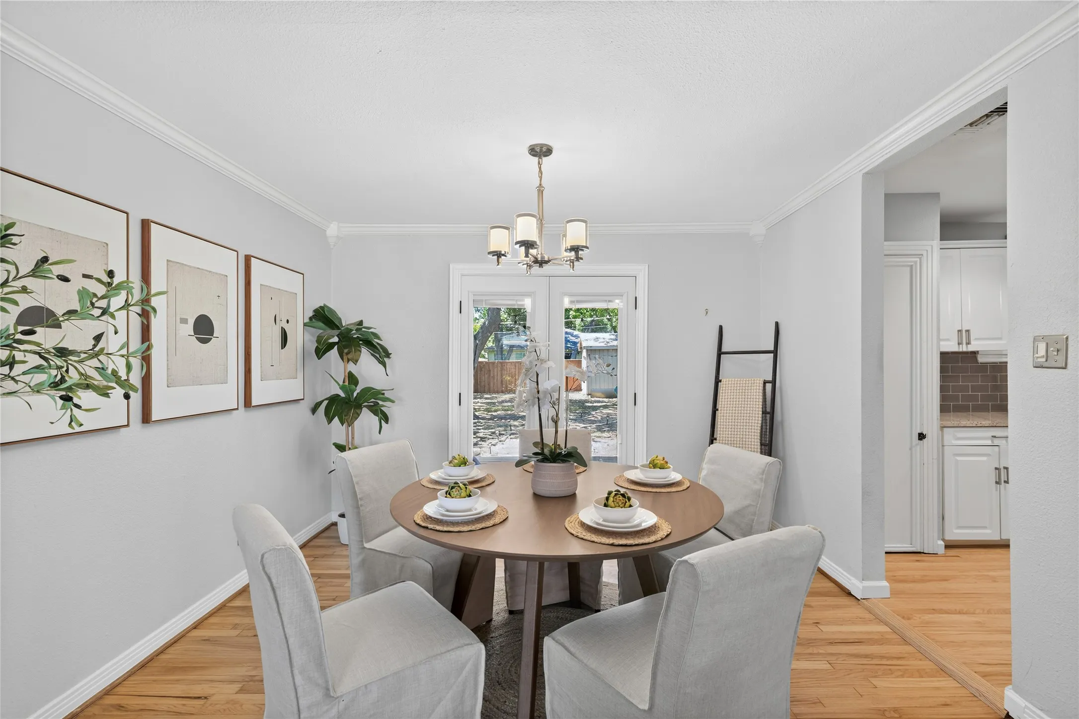 Hardwood flooring, crown molding, double French doors, recessed lighting, and a chandelier