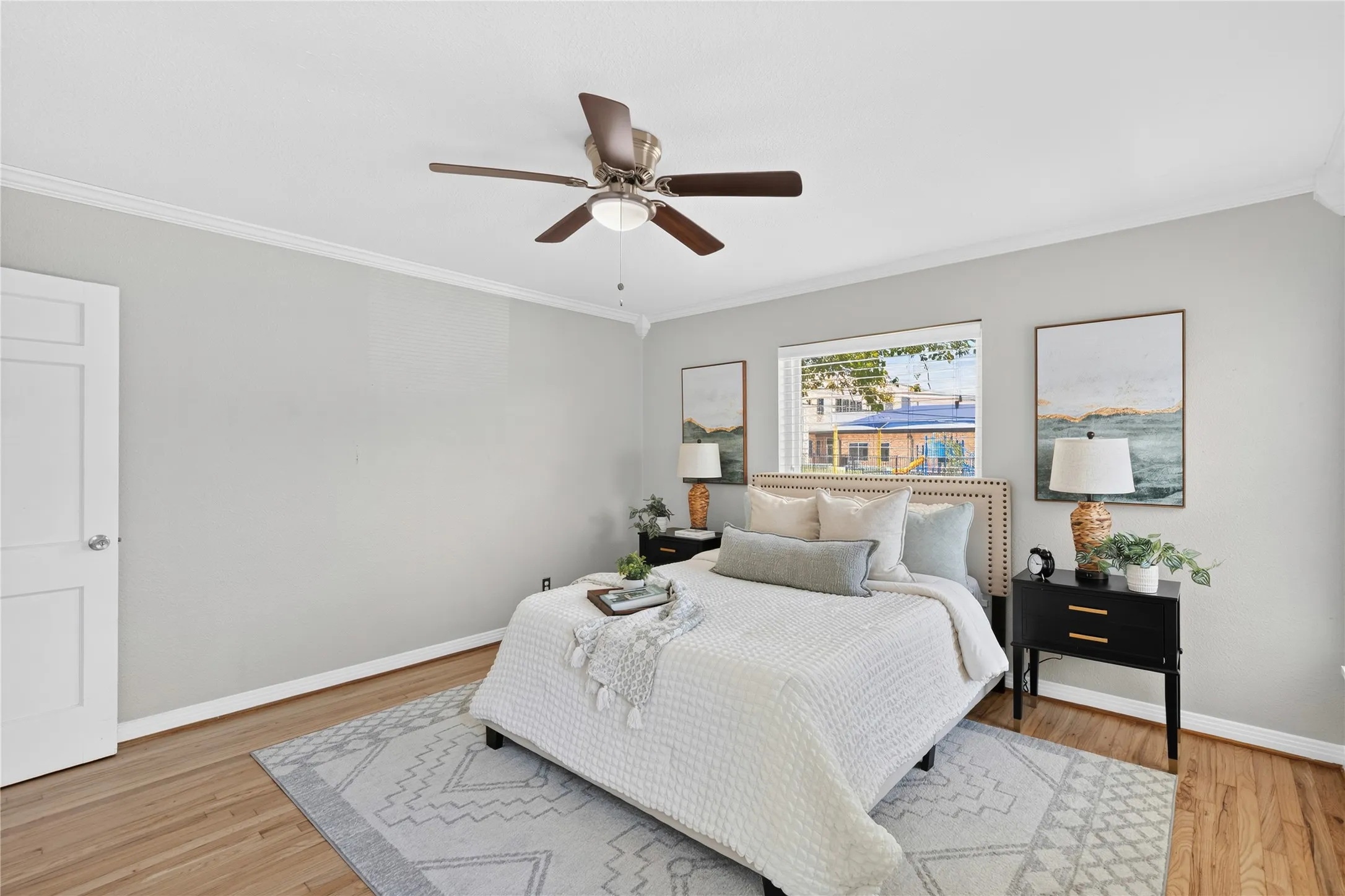 Wood-finish flooring, white trim, and a ceiling fan with integrated lighting