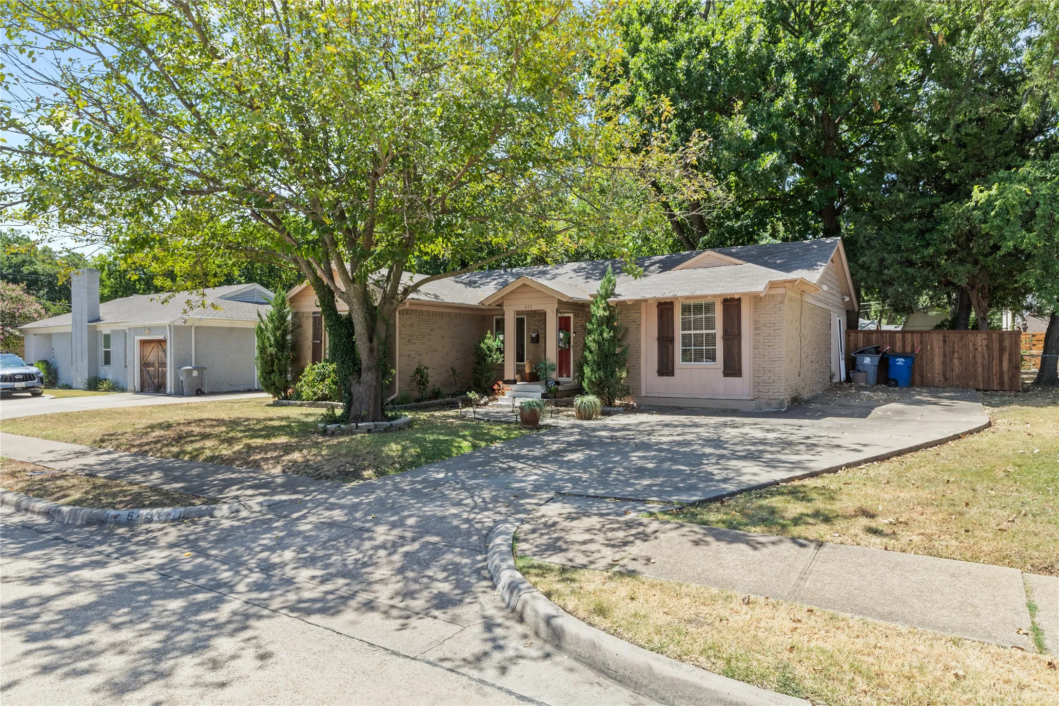 Brick exterior, mature front yard tree, concrete driveway, and front entry