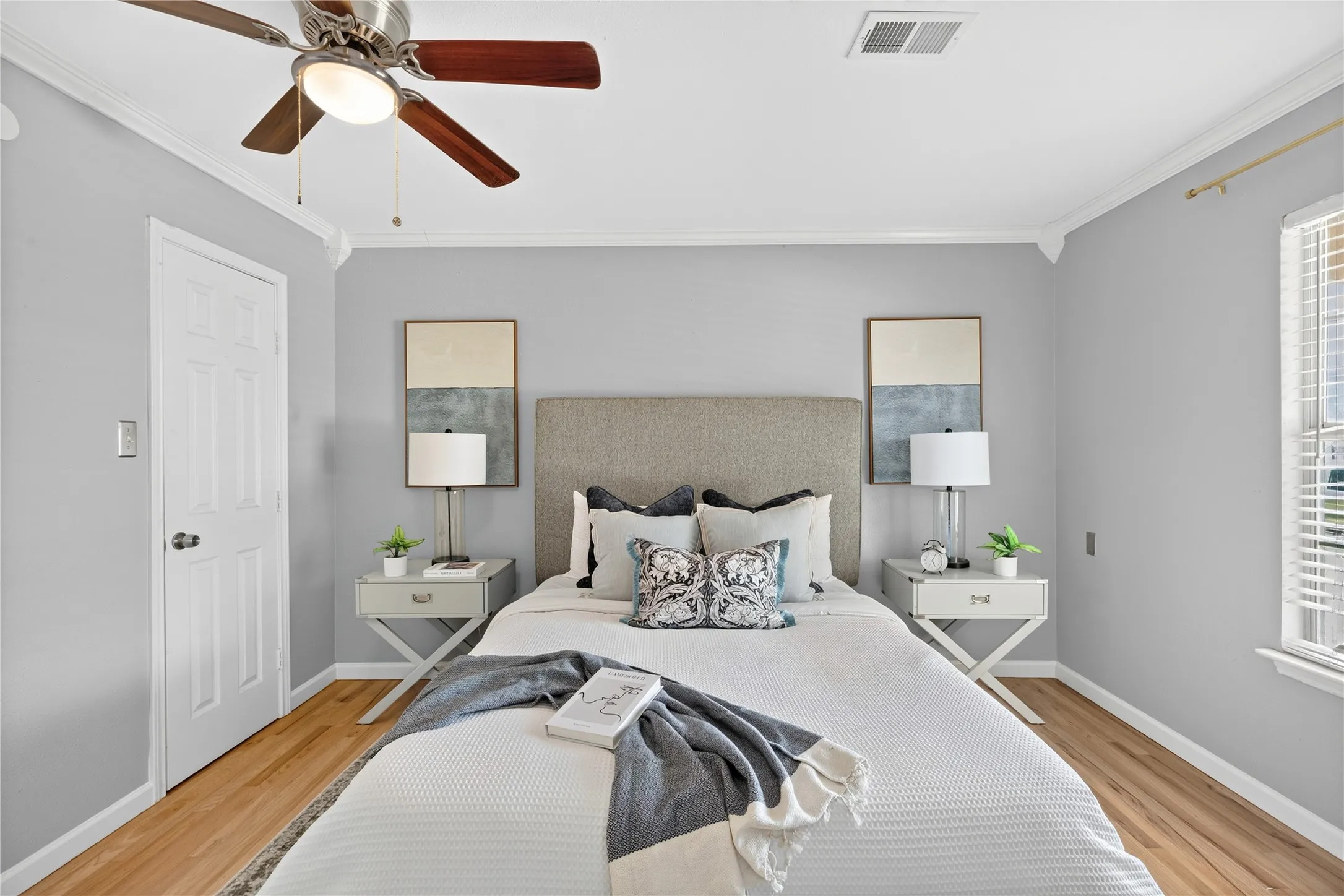 Wood-finish flooring, crown molding, and a ceiling fan with integrated lighting