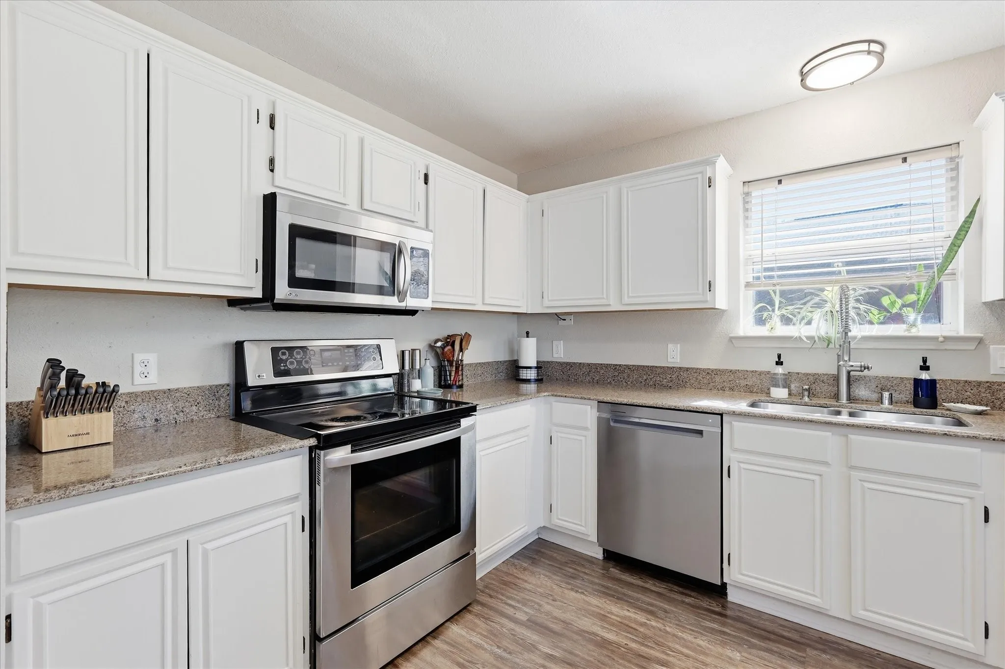 Matching stainless steel range, microwave, dishwasher, and under mount kitchen sink with upgraded faucet.