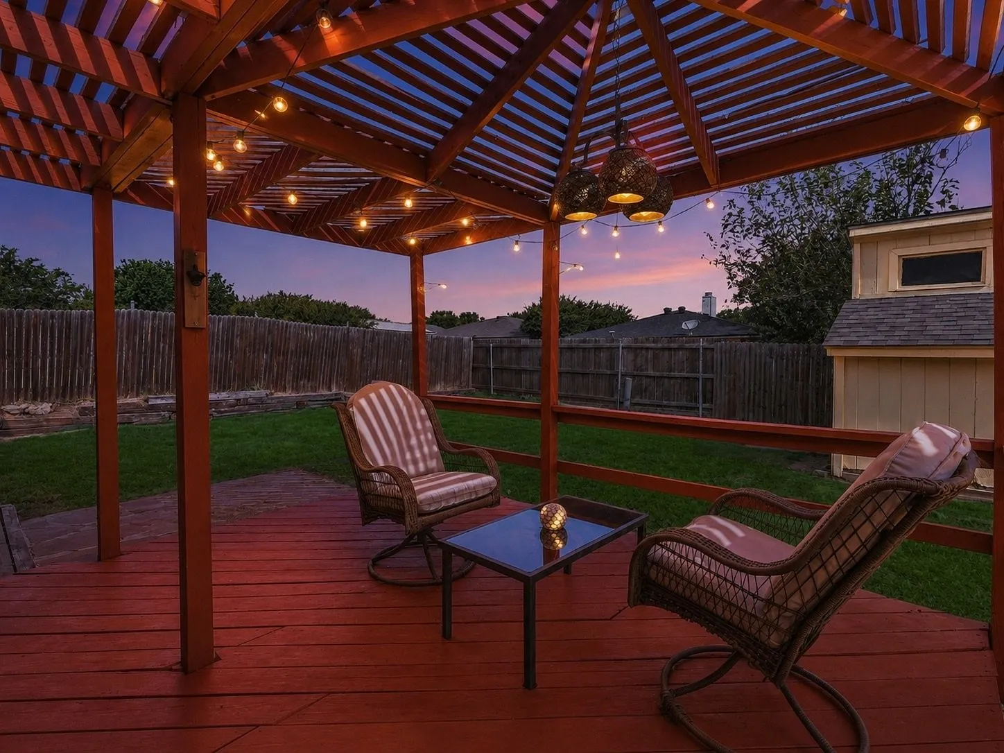 Backyard deck with wooden lattice cover overlooking sizable backyard.