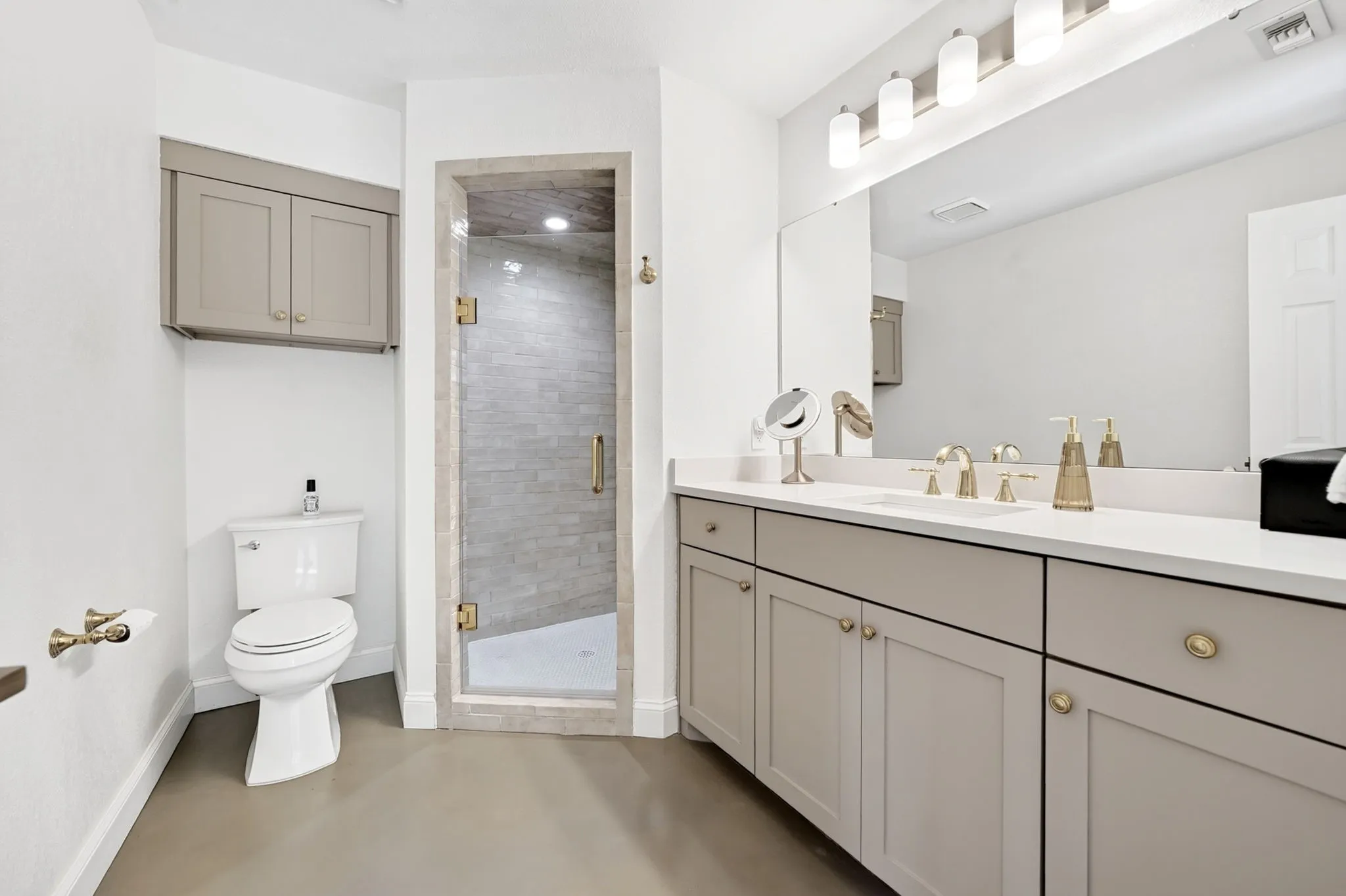 Double vanity with integrated sinks, frameless mirror, and modern light fixture