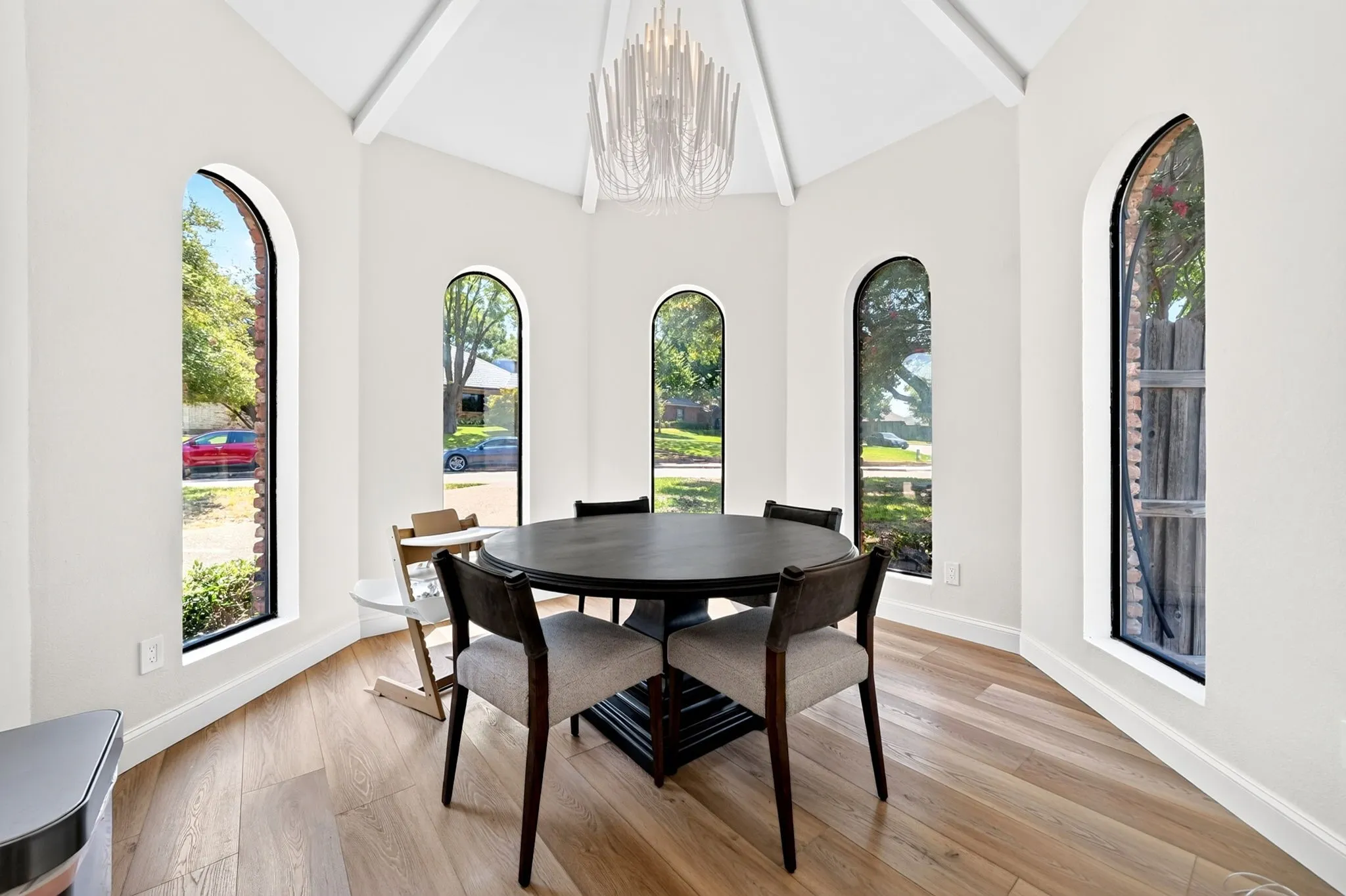 Octagonal room with wood-finish flooring, vaulted ceiling, and multiple arched windows